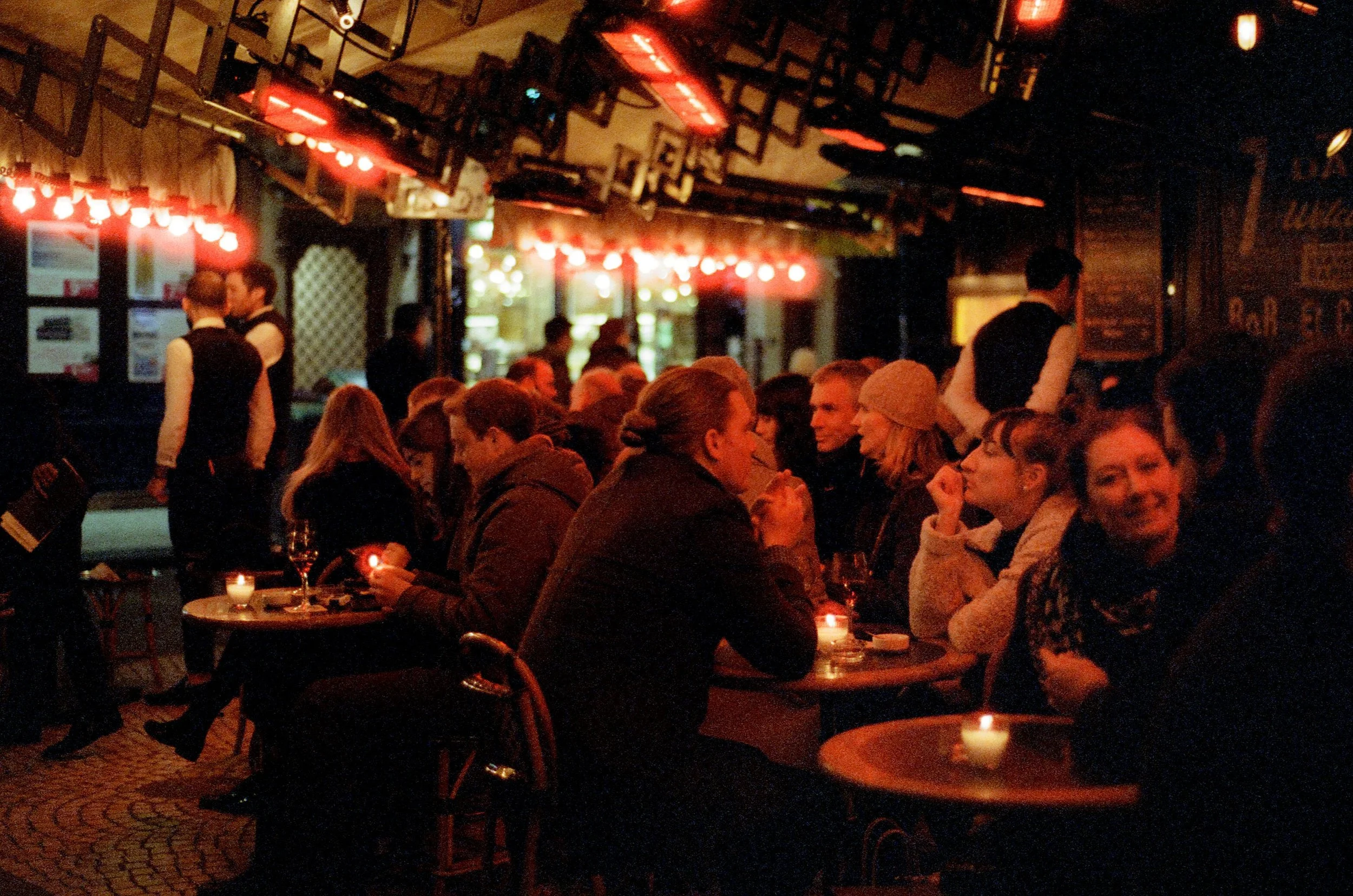 Charlie Michael Photography | Award Winning City Photography | LinkedIn | BCG | 35mm Kodak Portra 400 Nikon | on a wintertime evening parisians socialize under the warm glow at an outdoor cafe very french.jpg