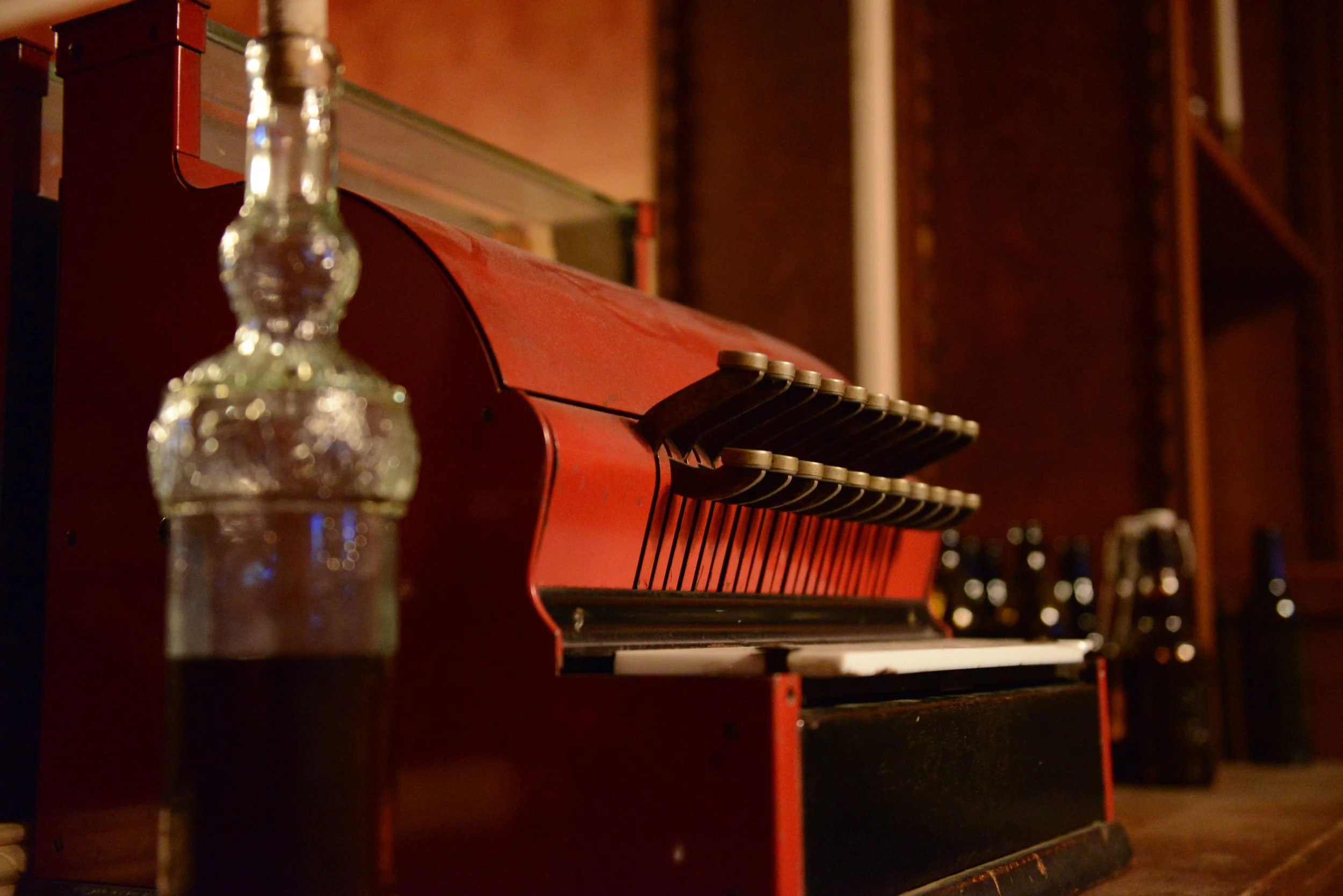 Behind the bar sits an antique cash register and a bottle of whiskey