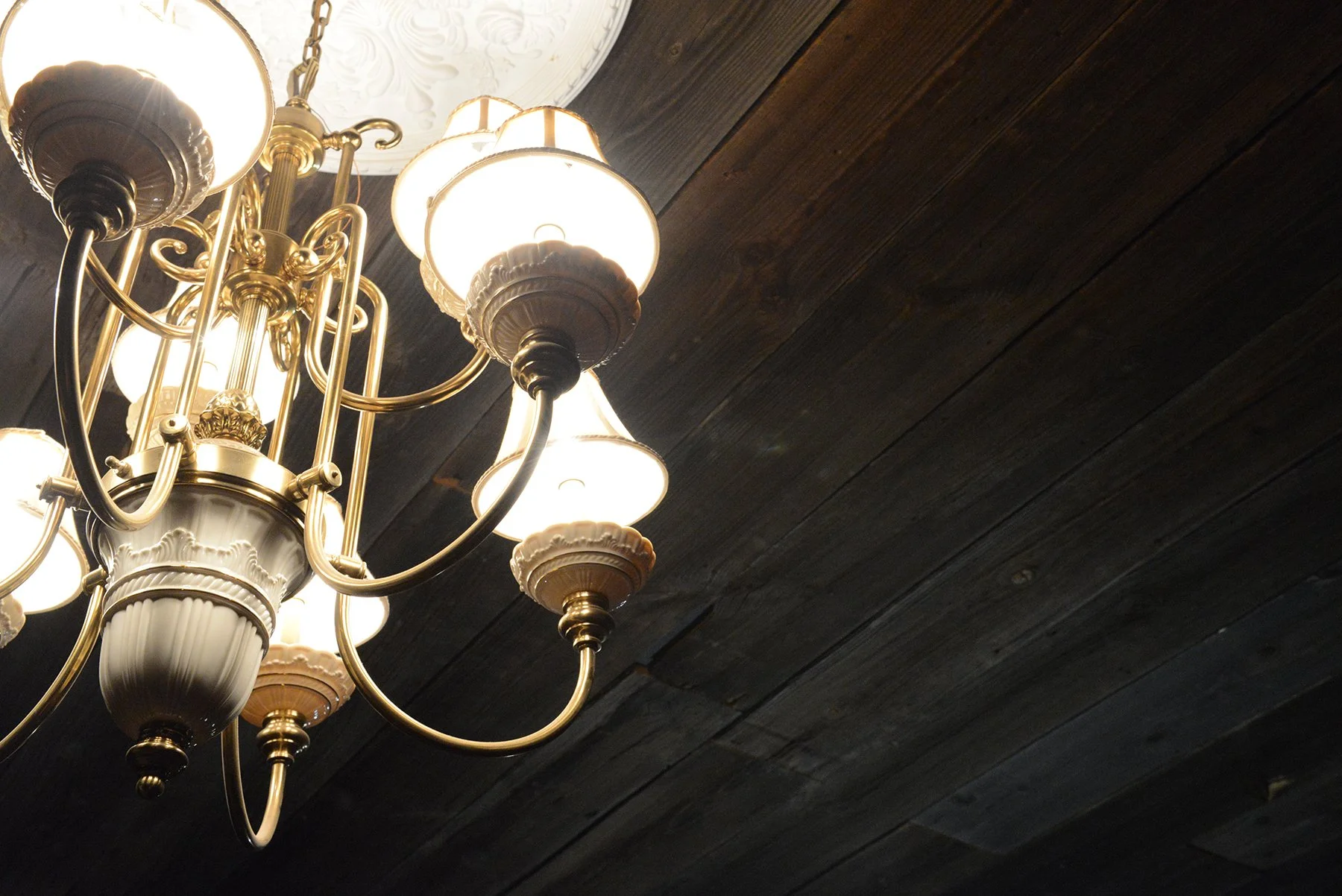 A beautiful porcelain and gold chandelier hangs from the ceiling in the center of the Fox Tail Saloon