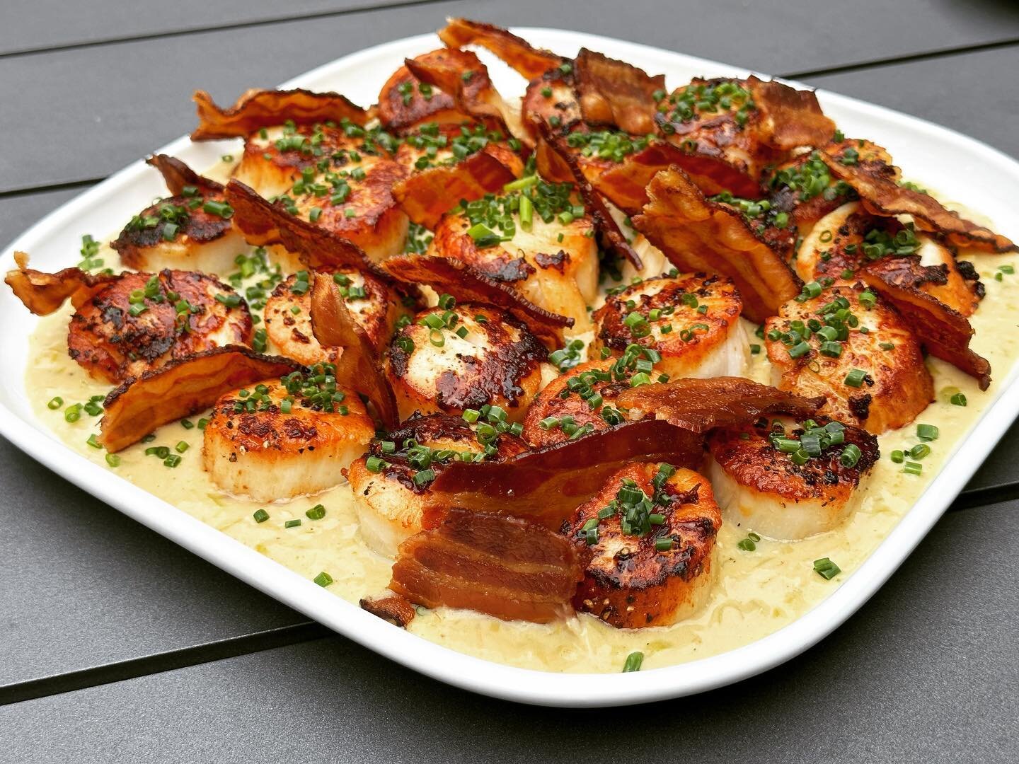 Pan seared scallops on a bed of leek pur&eacute;e and crisp bacon.