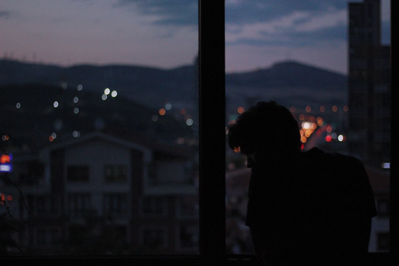 silhouette-of-a-man-looking-at-the-window-at-night