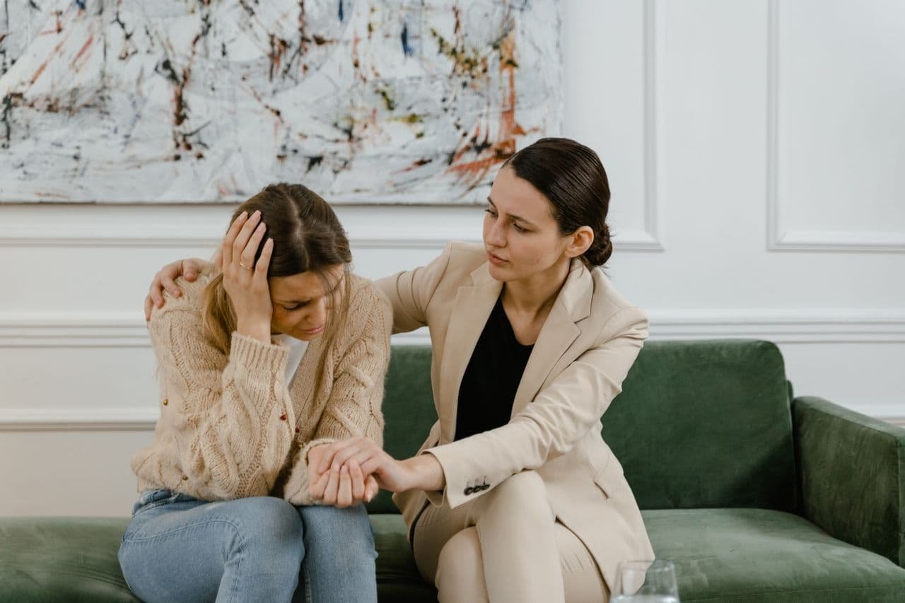 two-women-talking-while-sitting-on-the-sofa