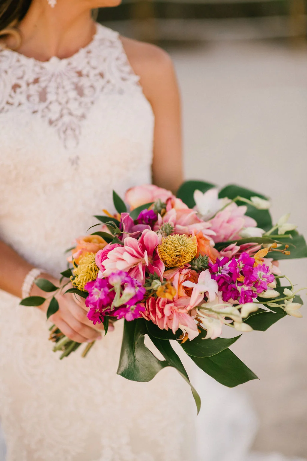 Our bride’s bouquet by Beautiful Kreations is delightfully scattered with protea, larkspur, and alpinia with a split leaf philodendron as the base.