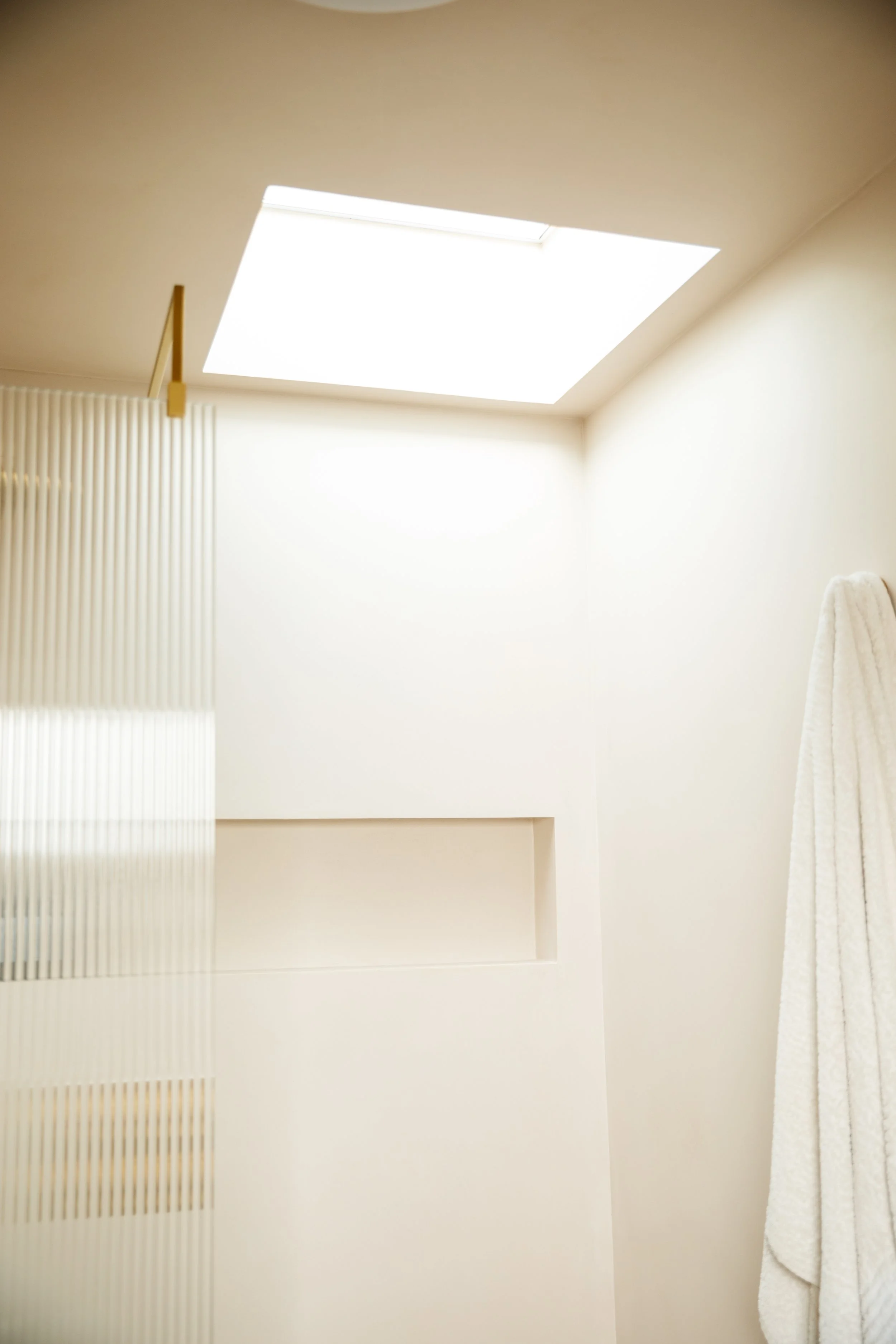 Blog post image showing a bright shower corner with a skylight above