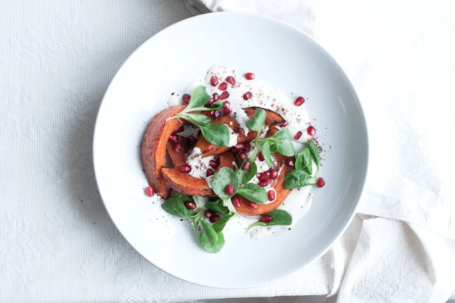 ROASTED RED KURI SQUASH WITH SUMAC, POMEGRANATES AND GREENS (V+, GF, GR, V, P, NF)