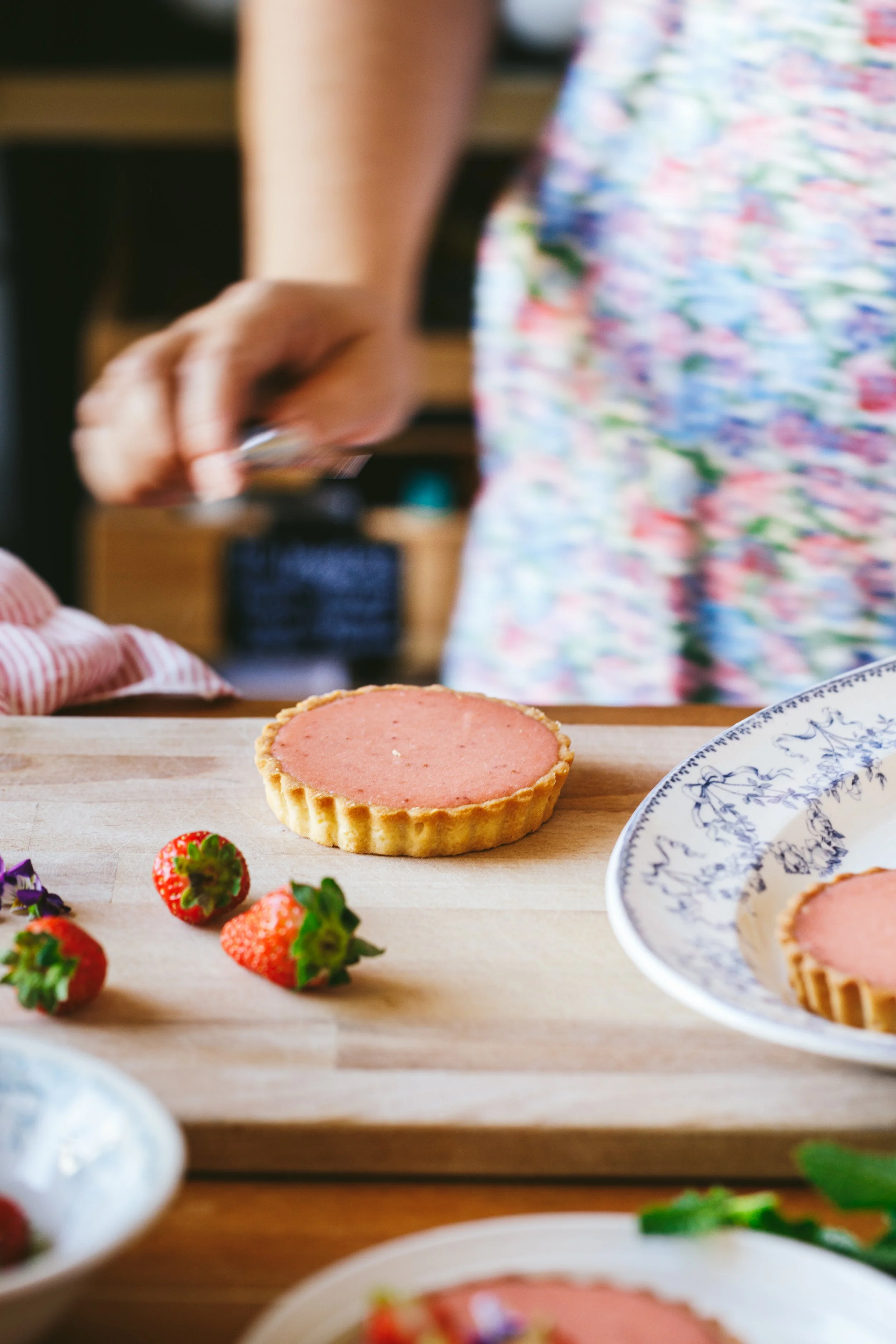 Blog post image showing a person preparing a strawberry tart