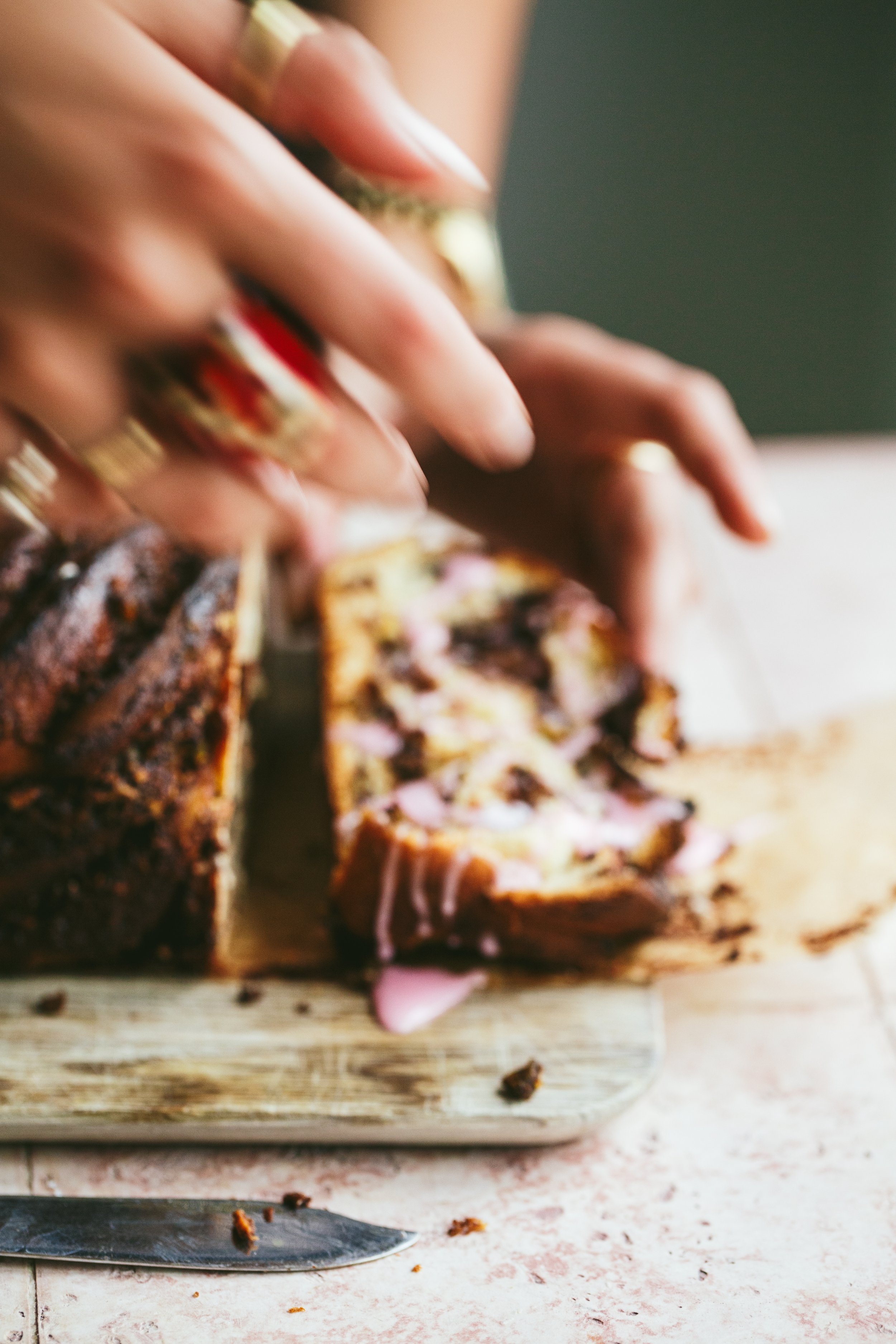 Blog post image showing hands cutting a loaf cake, the image is blurry giving the impression of movement
