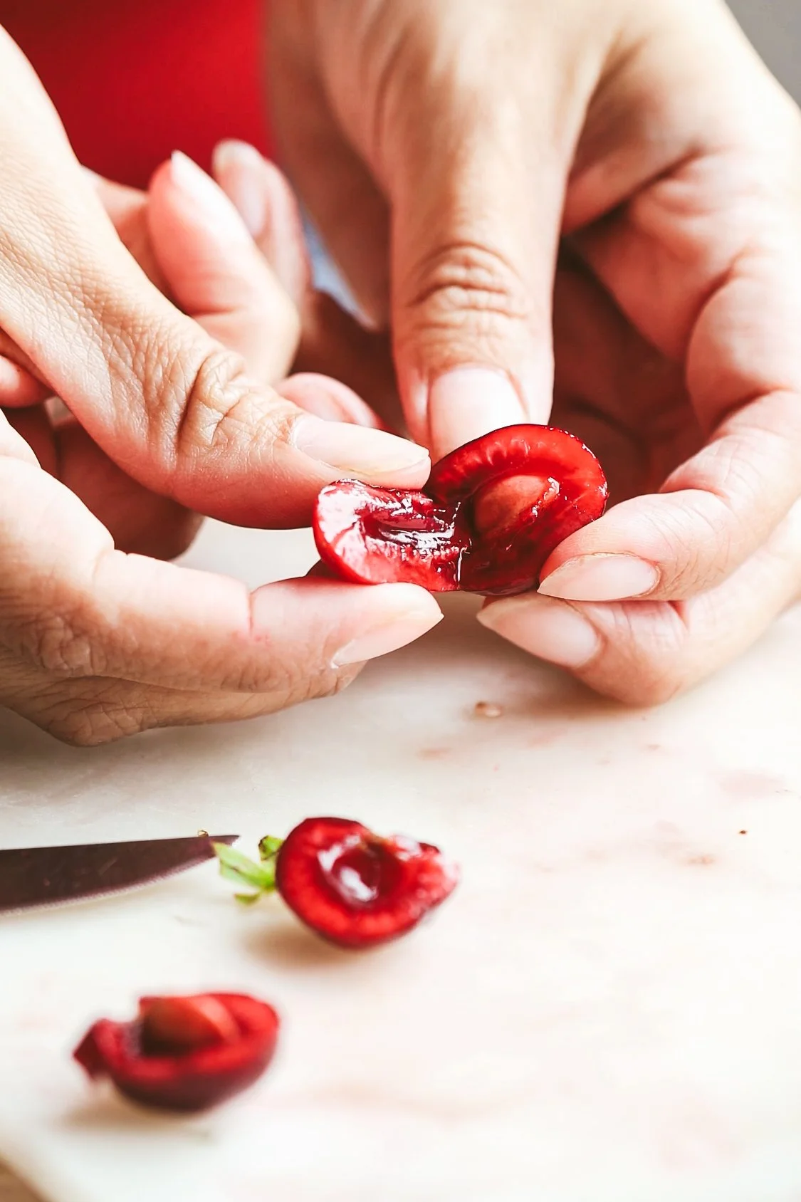 Blog post image showing hands holding a halved cherry