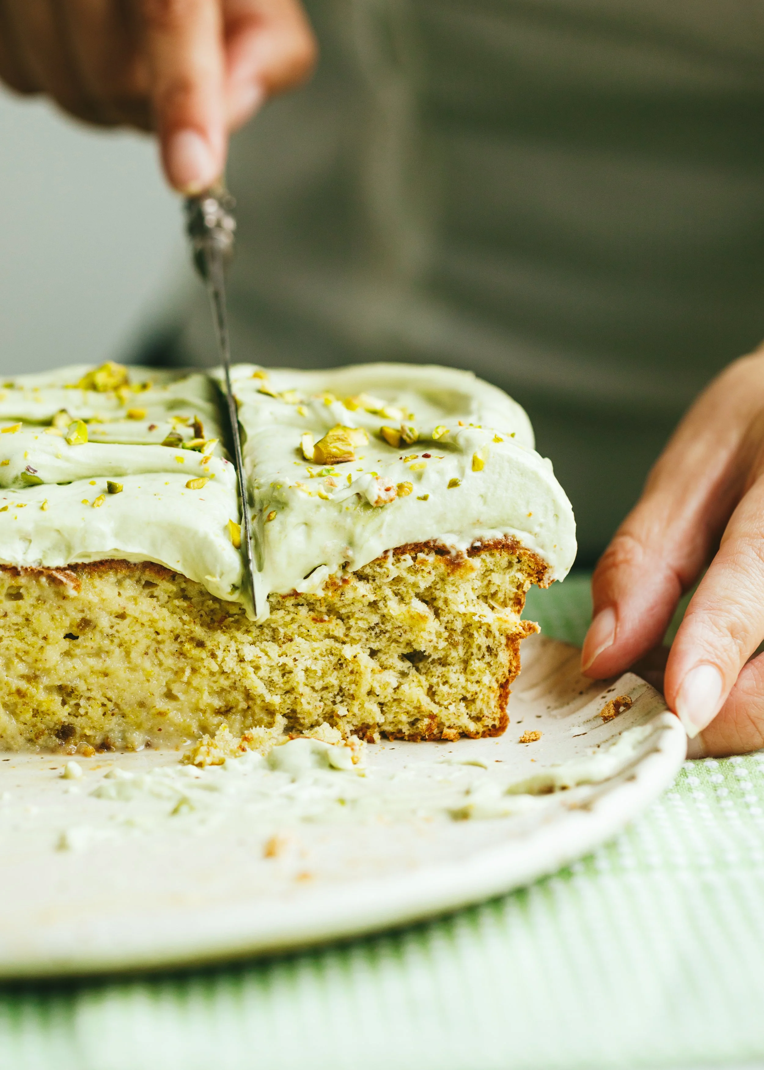 Kimberly Espinel portfolio image showing a hand cutting a piece of pistachio cake