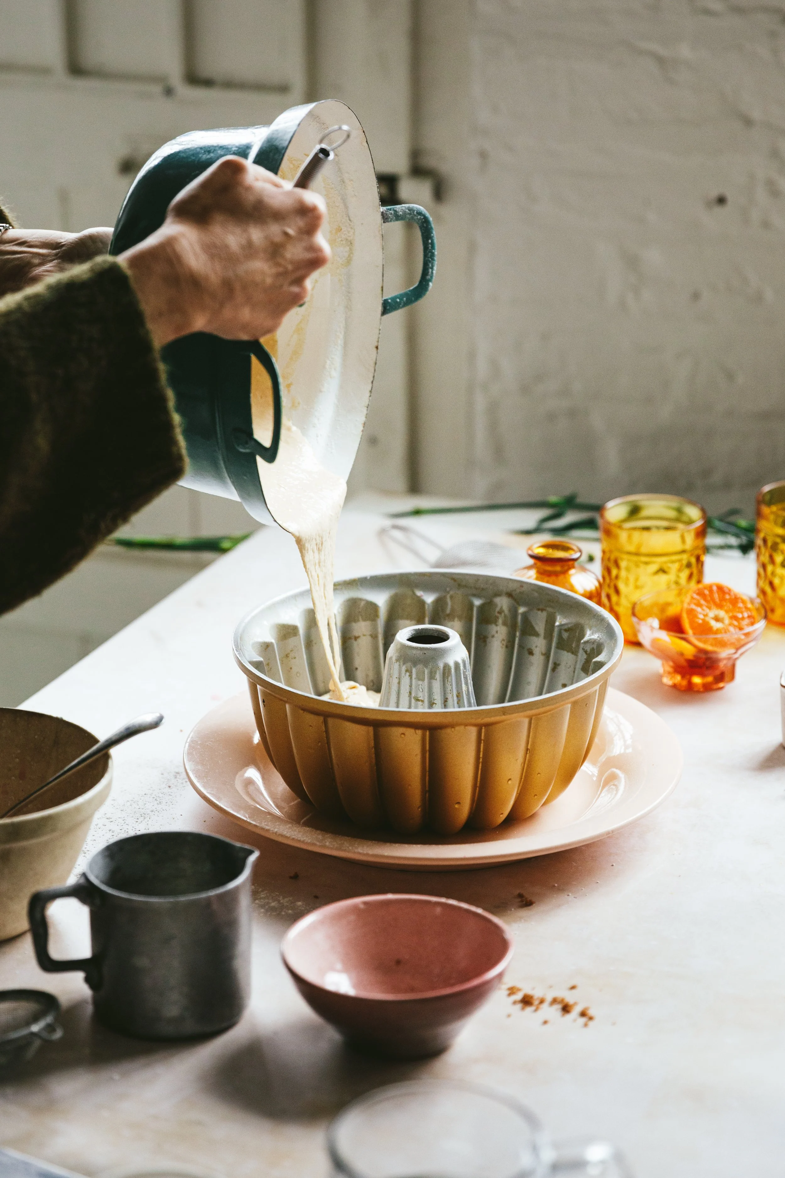 Blog post image showing hands pouring cake mix into a bundt pan