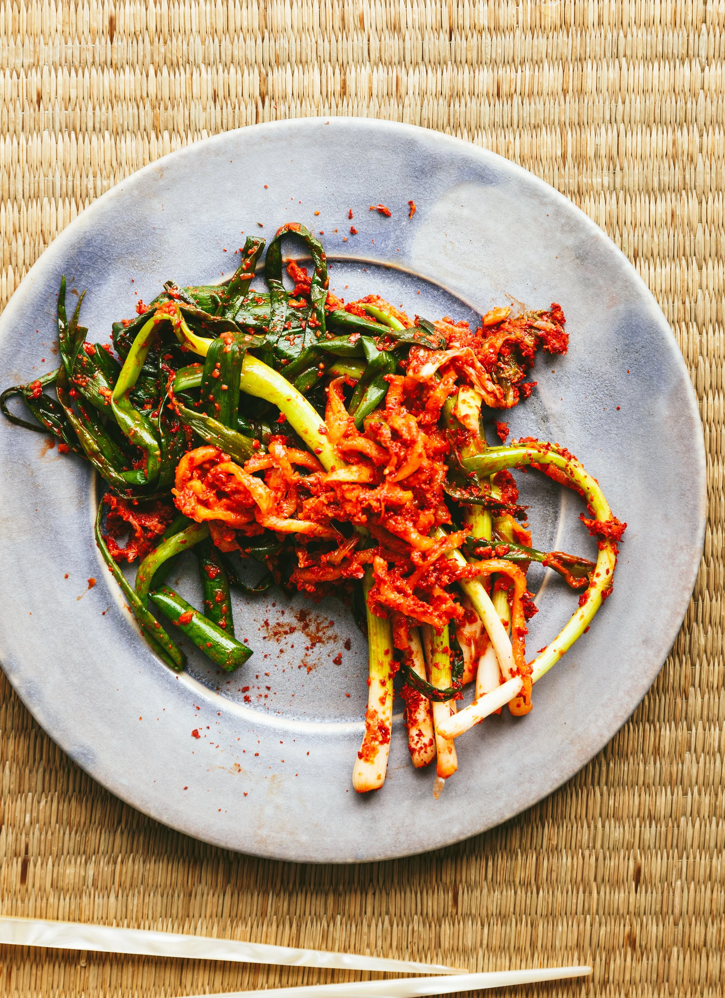 Kimberly Espinel portfolio image showing some greens on plate with some kimchi on top.