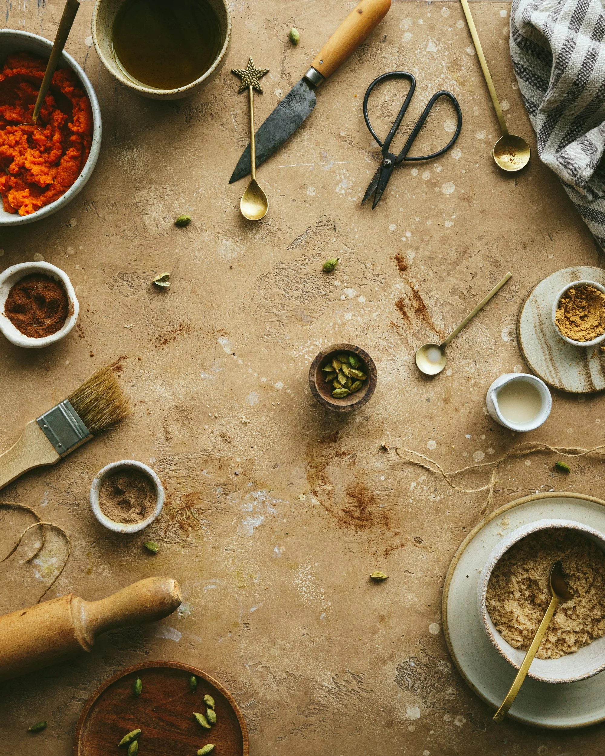 Image shows various food props such as pinch bowls with spices and vintage utensils on a pretty photography backdrop