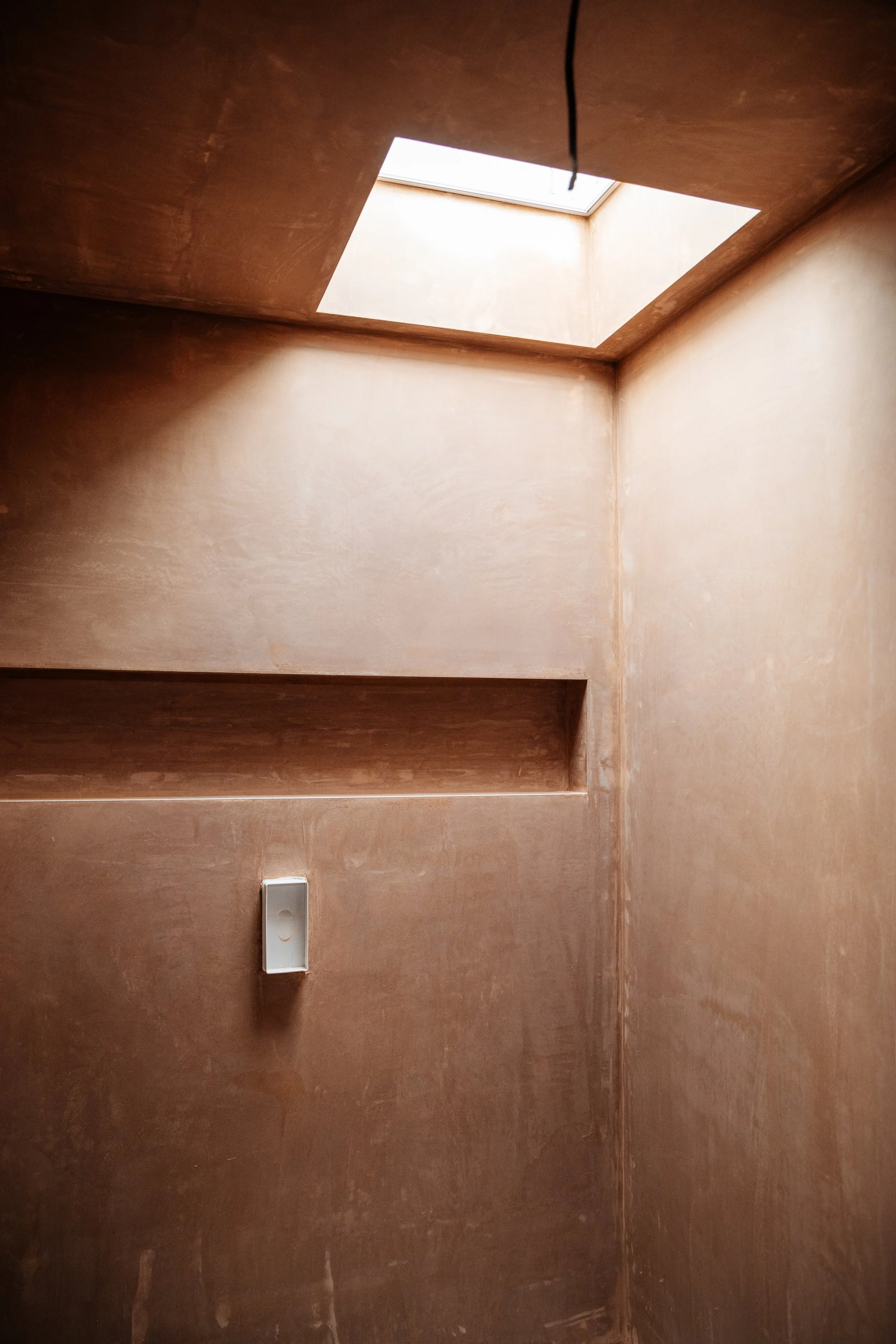 Blog post image showing a corner space with plastered walls and a skylight above