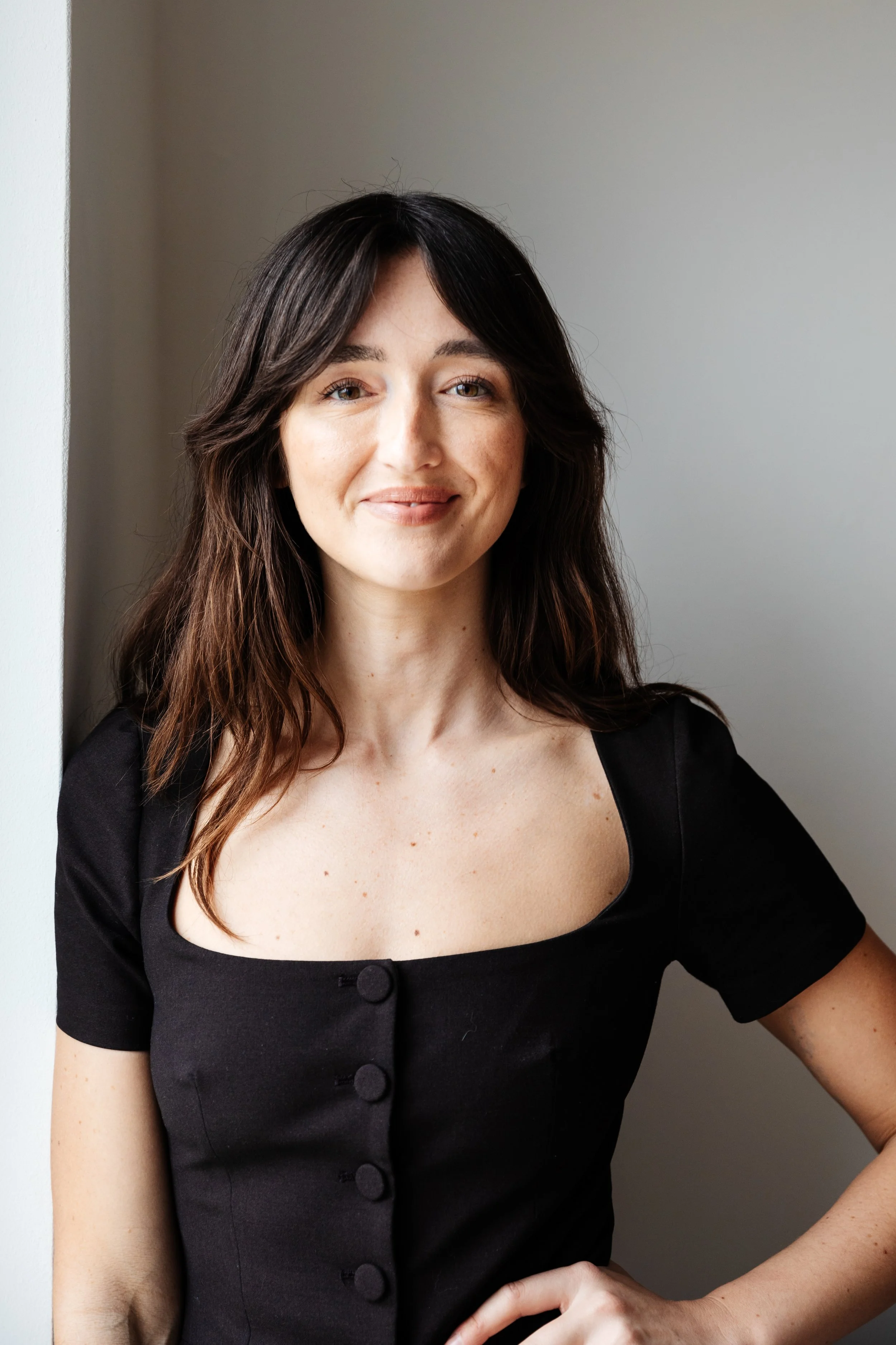 Kimberly Espinel portfolio image showing a person with long brown hair facing the camera and smiling.