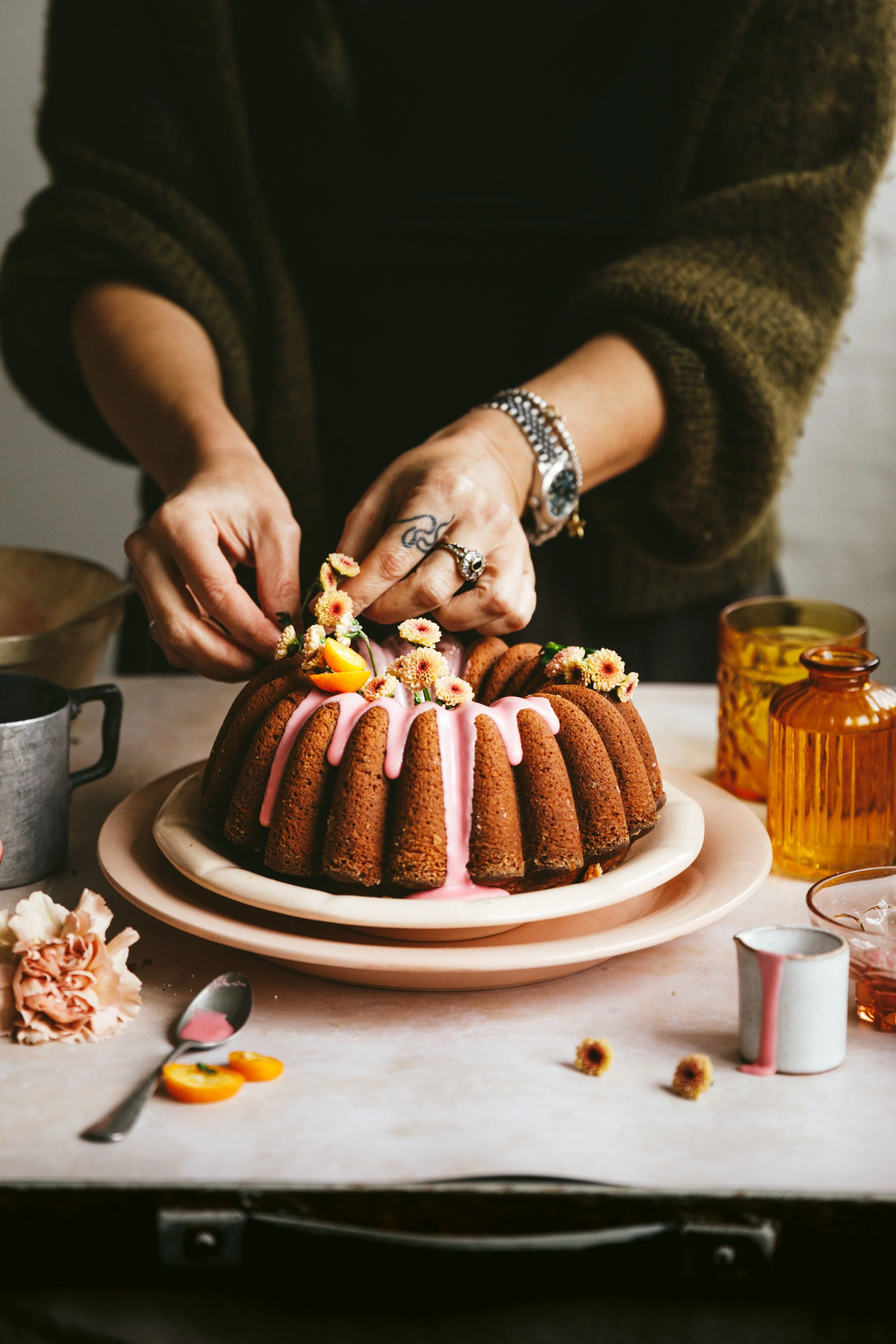 Blog post image showing hands decorate a bundt cake with flowers