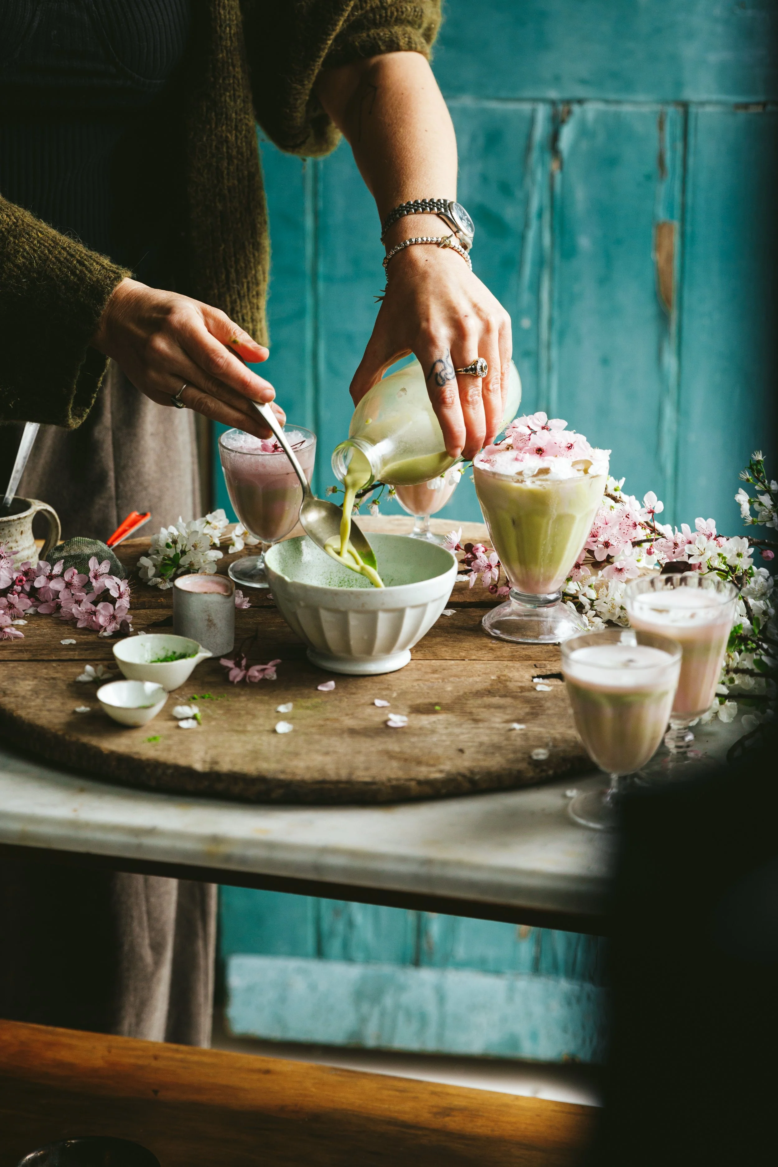 Blog post image showing hands pouring a milky drink into a bowl surrounded by spring flowers