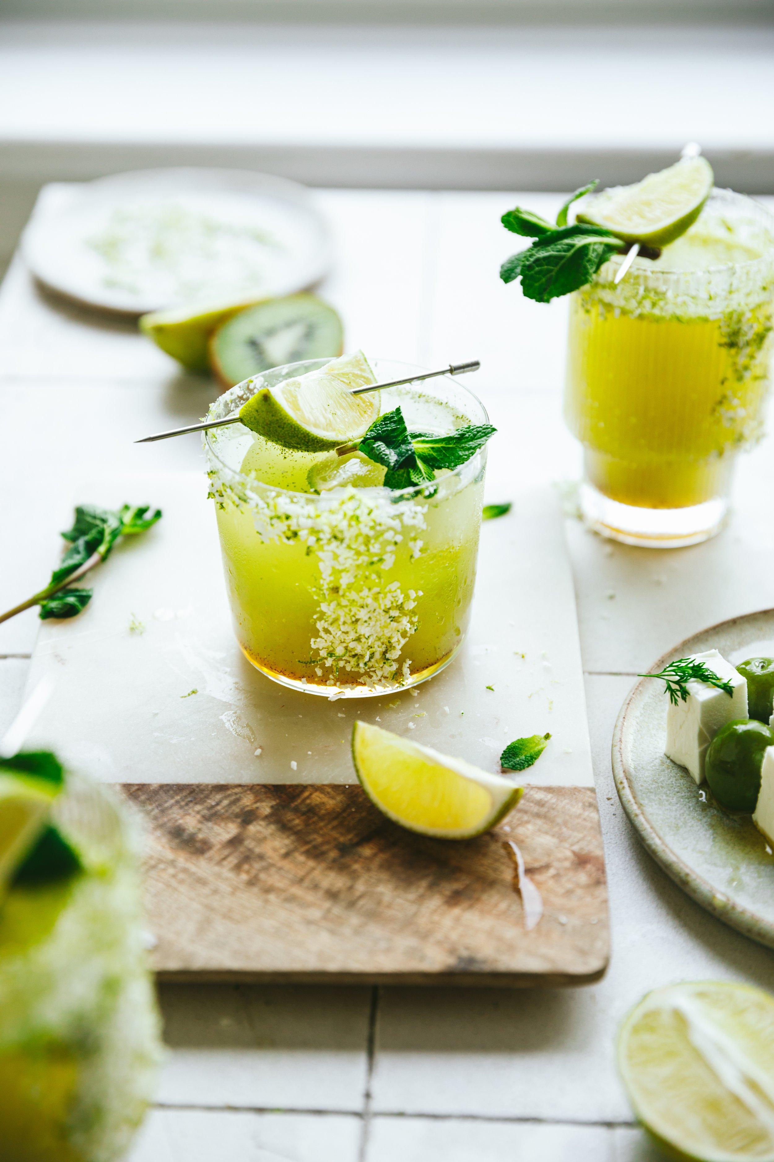 Blog post image showing a bright backlit scene with pretty green drinks garnished with lime wedges and mint