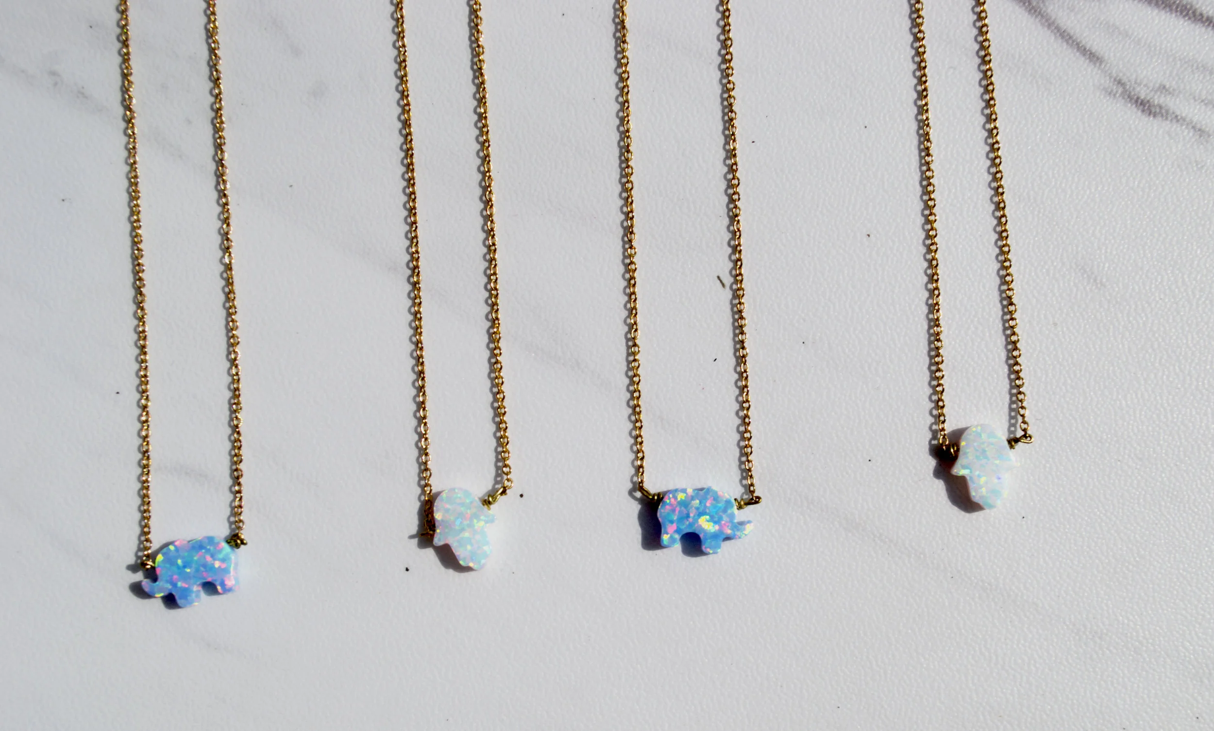 O P A L S $30 Handmade. Opal Elephant in blue or Opal Hamsa Hand in white. 14kt gold filled. Nickel-free. Please contact me to shop this item.