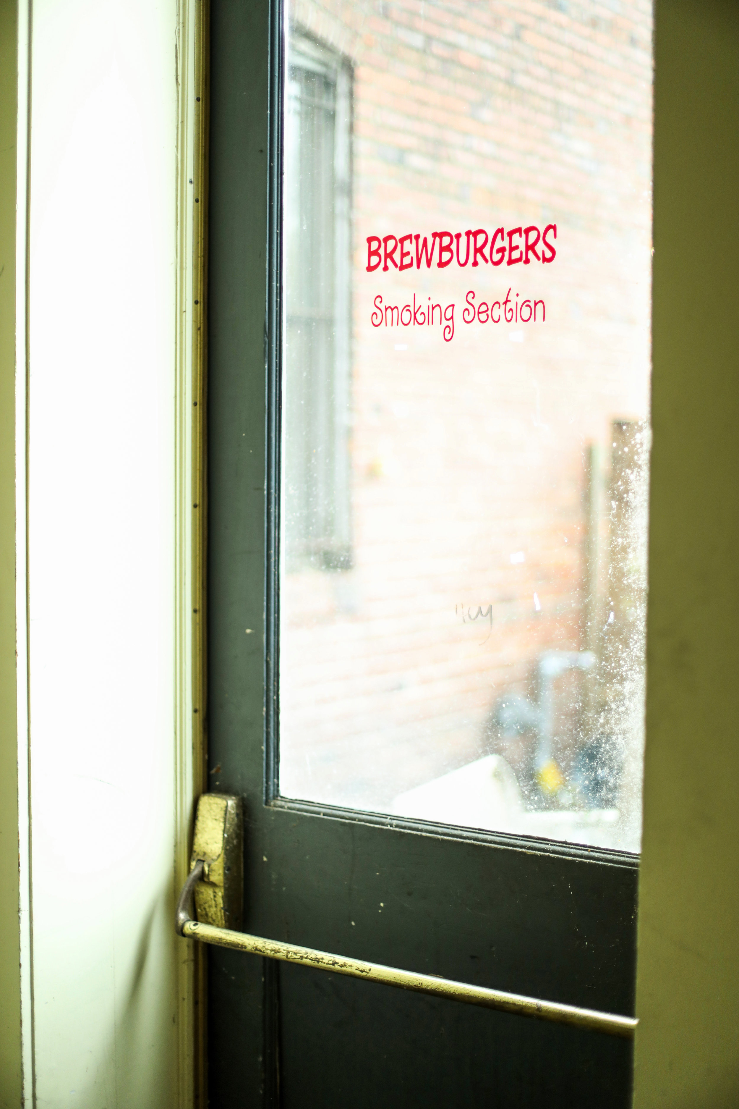 a push door with a "brewburger's smoking section" sign