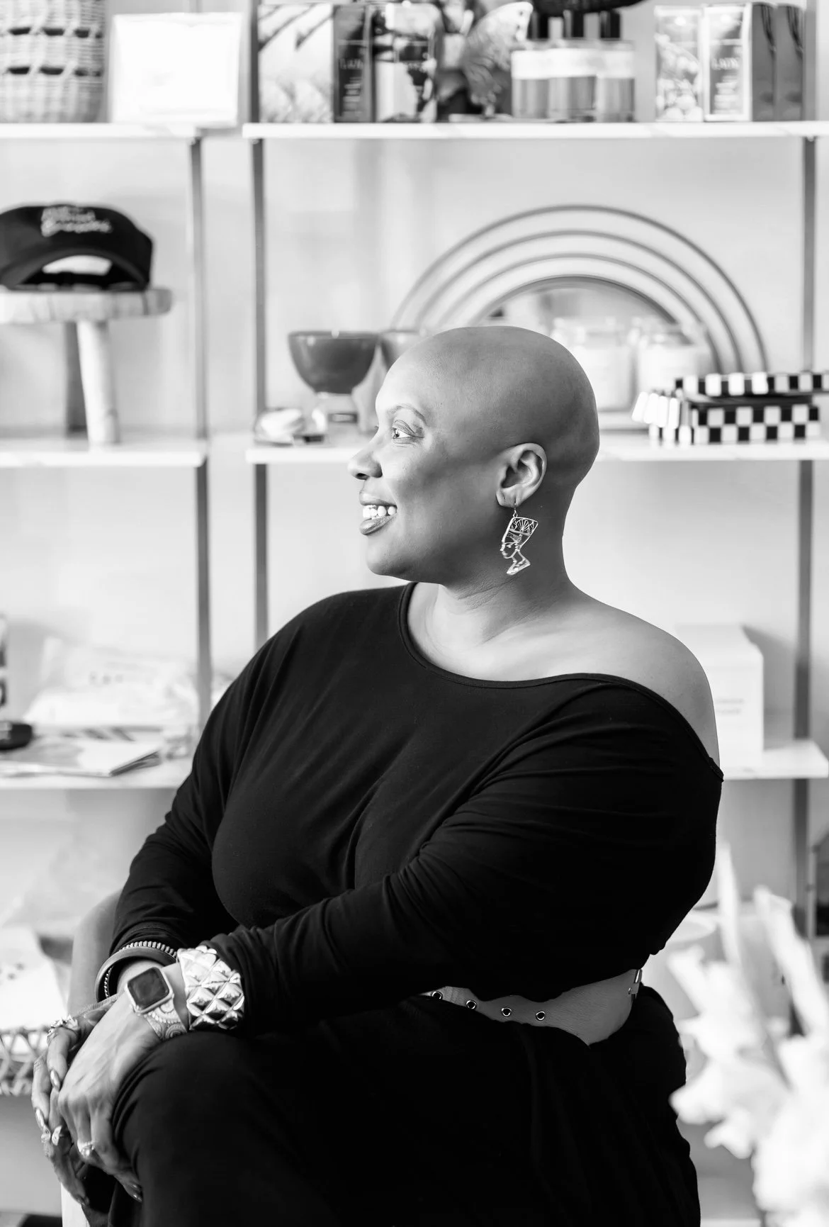Confident woman smiling in a modern studio space, captured in a black and white brand story portrait