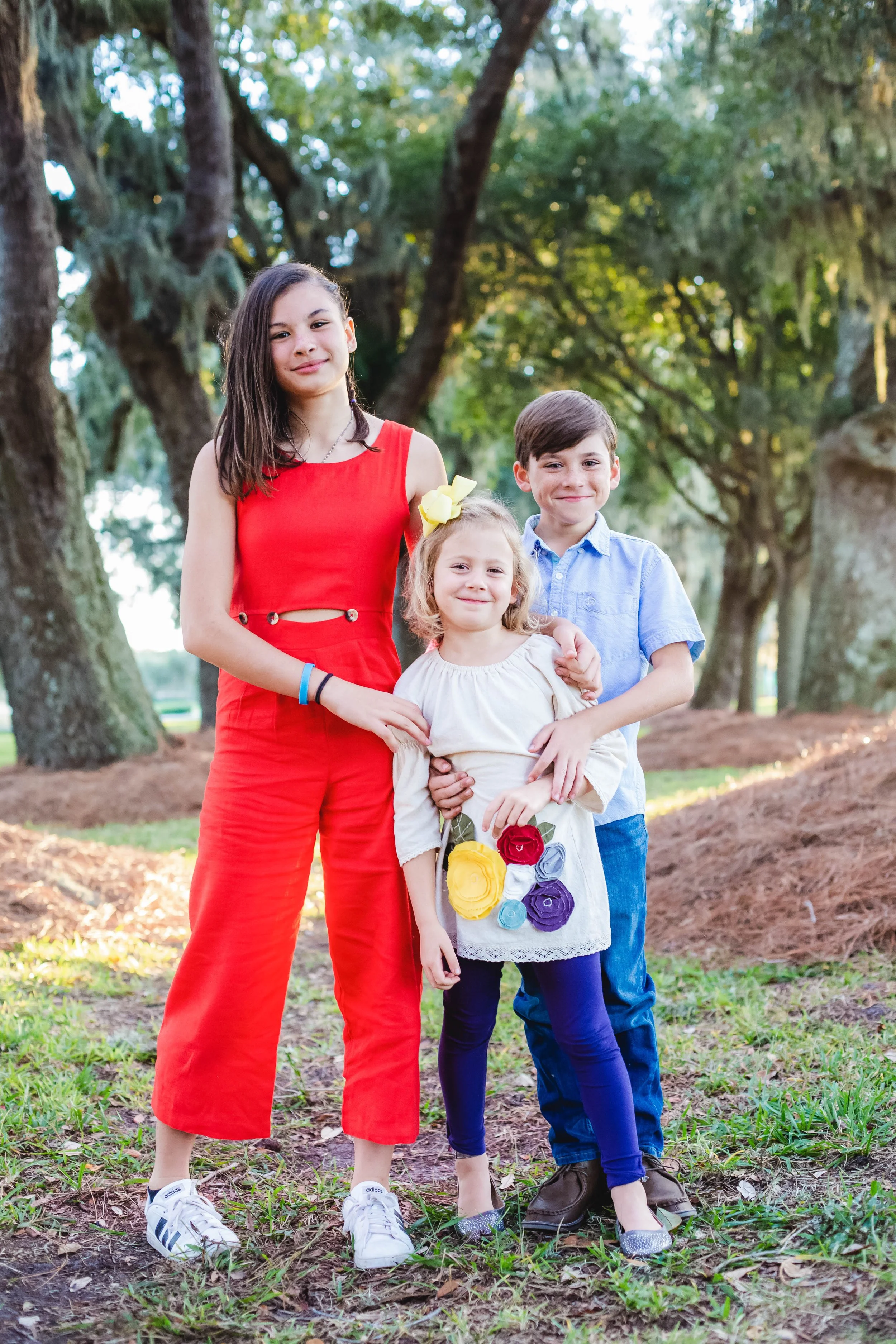 Children sharing a natural moment during a golden hour family storytelling session at Avenue of the Oaks on St. Simons Island