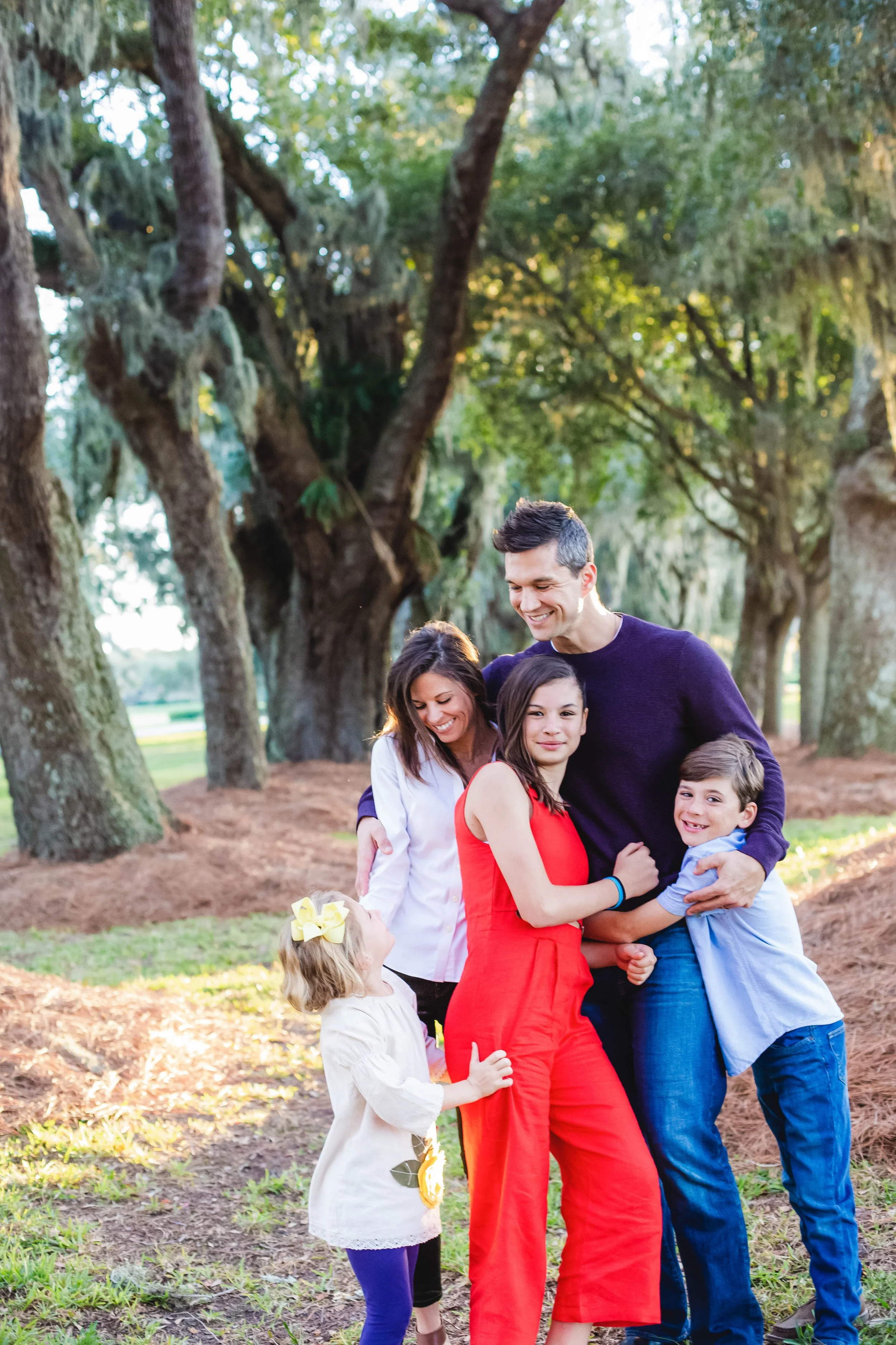 Family standing together at sunset during a candid storytelling photography session at Avenue of the Oaks on St. Simons Island