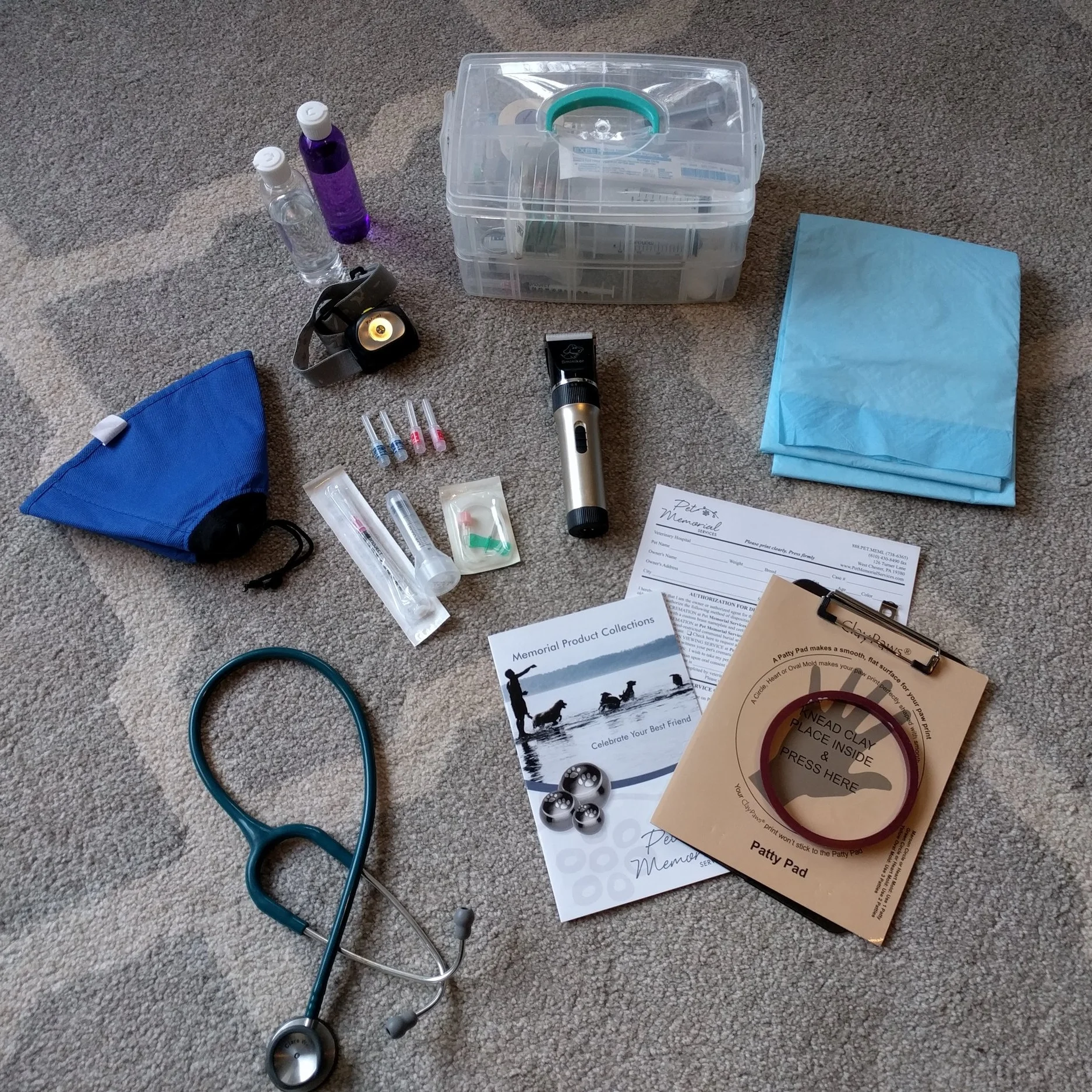 Some of the contents from my medical bag: At the top, I have alcohol and hydrogen peroxide, my tackle box of medical supplies, a headlamp in case the lights are too low for me to see you pet's veins, a soft e-collar for feisty cats or dogs (I also have a full set of muzzles in the car if needed. Thankfully I rarely need these), needles and syringes, clippers, pee pads, a stethoscope, information about specialty urns if desired, consent forms, and material to make a clay paw impression. 
