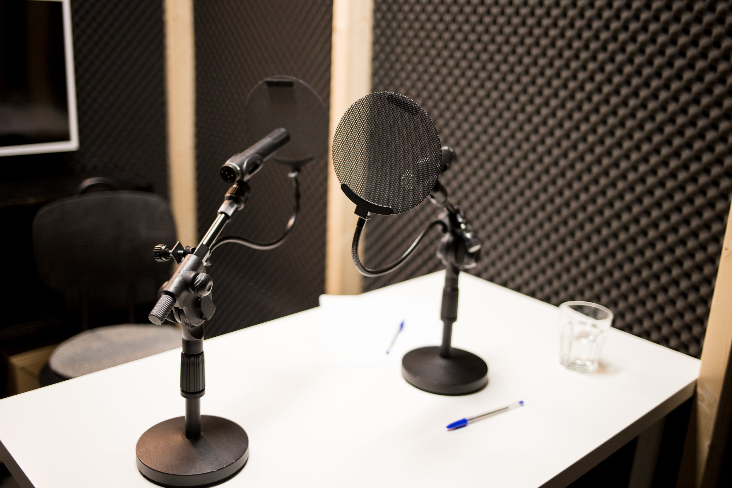 microphones_on_a_table_inside_a_podcast_studio.jpg