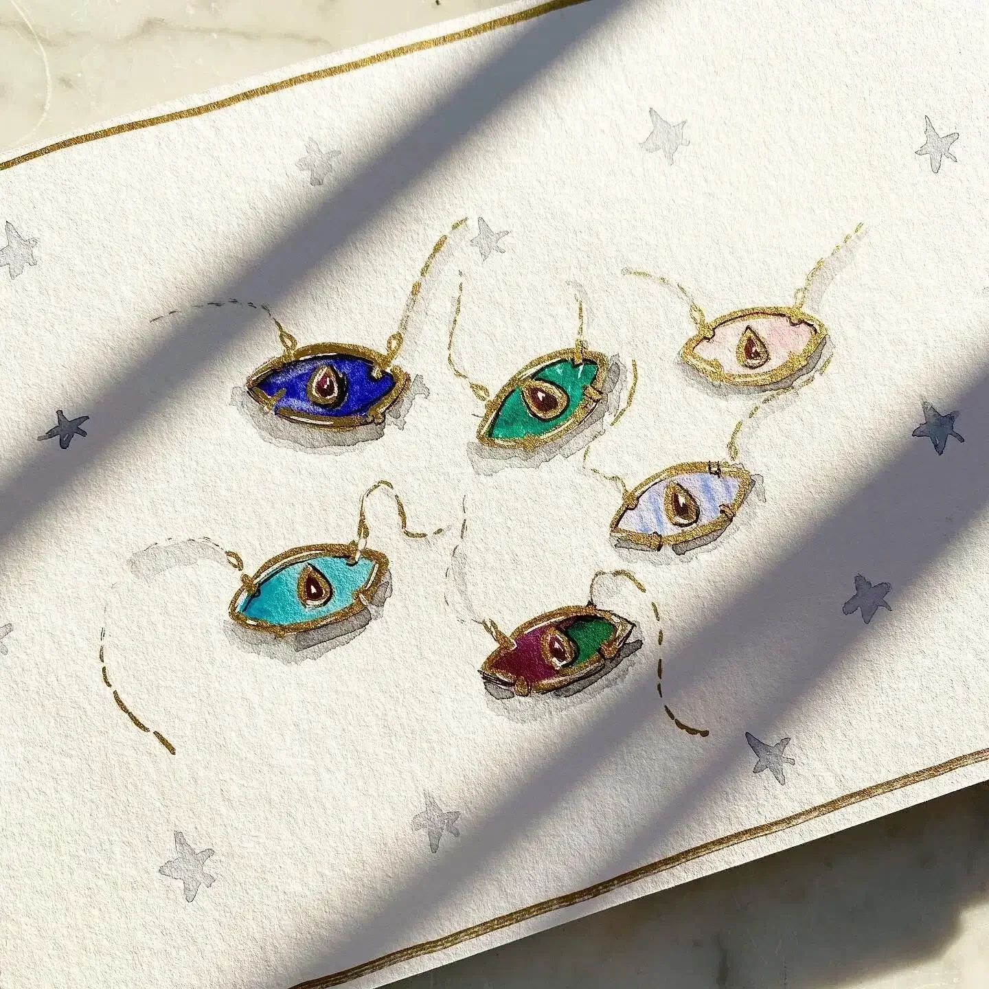 Dessins de guirlandes lumineuses en forme d'yeux colorés, encadrés de fil doré, avec un fond de petits étoiles gris clair.