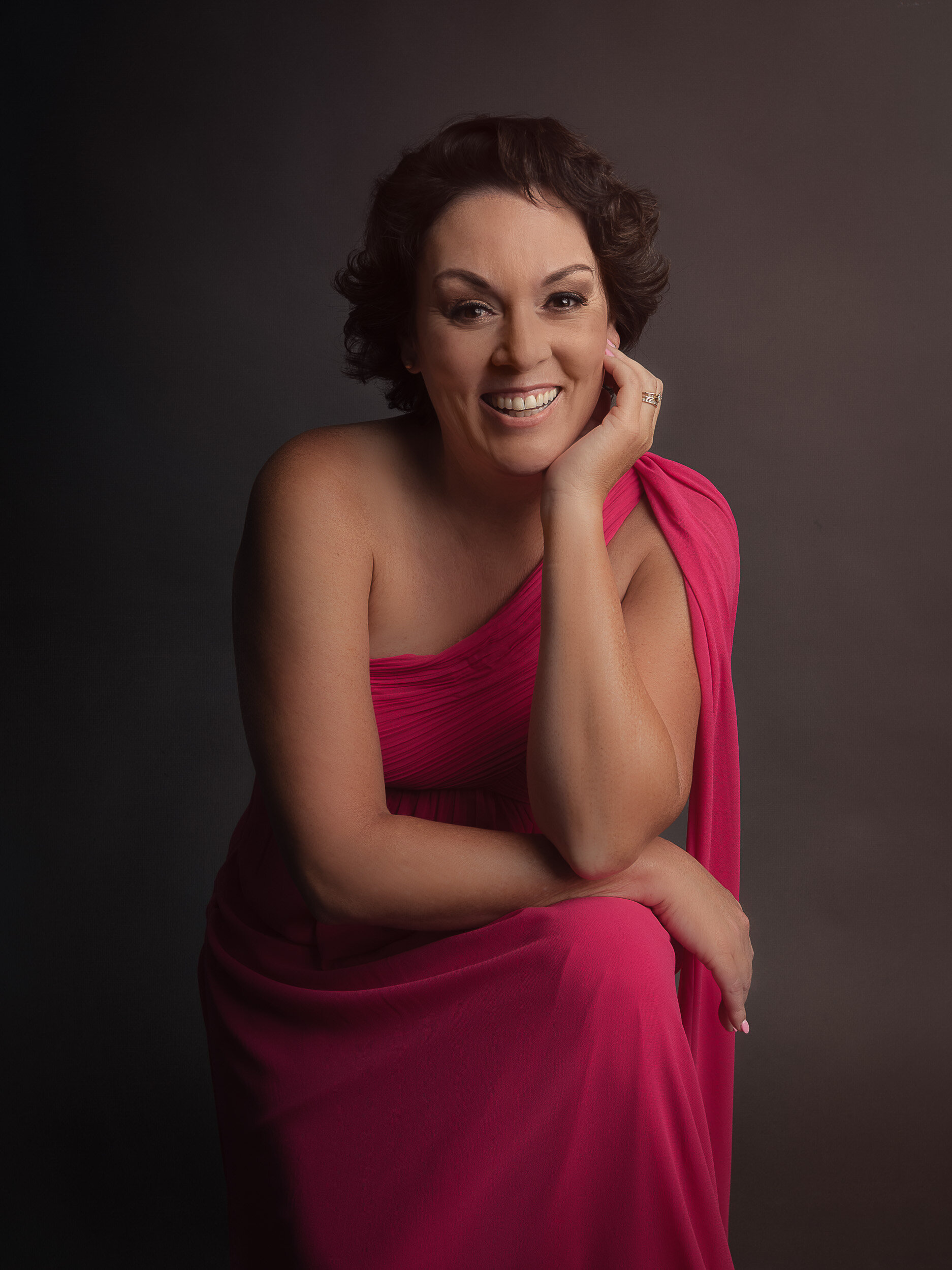 beautiful breast cancer survivor shot in flowy hot pink dress in a glamour photography pose at Ana Lanier Portrait Studio in Dallas, TX