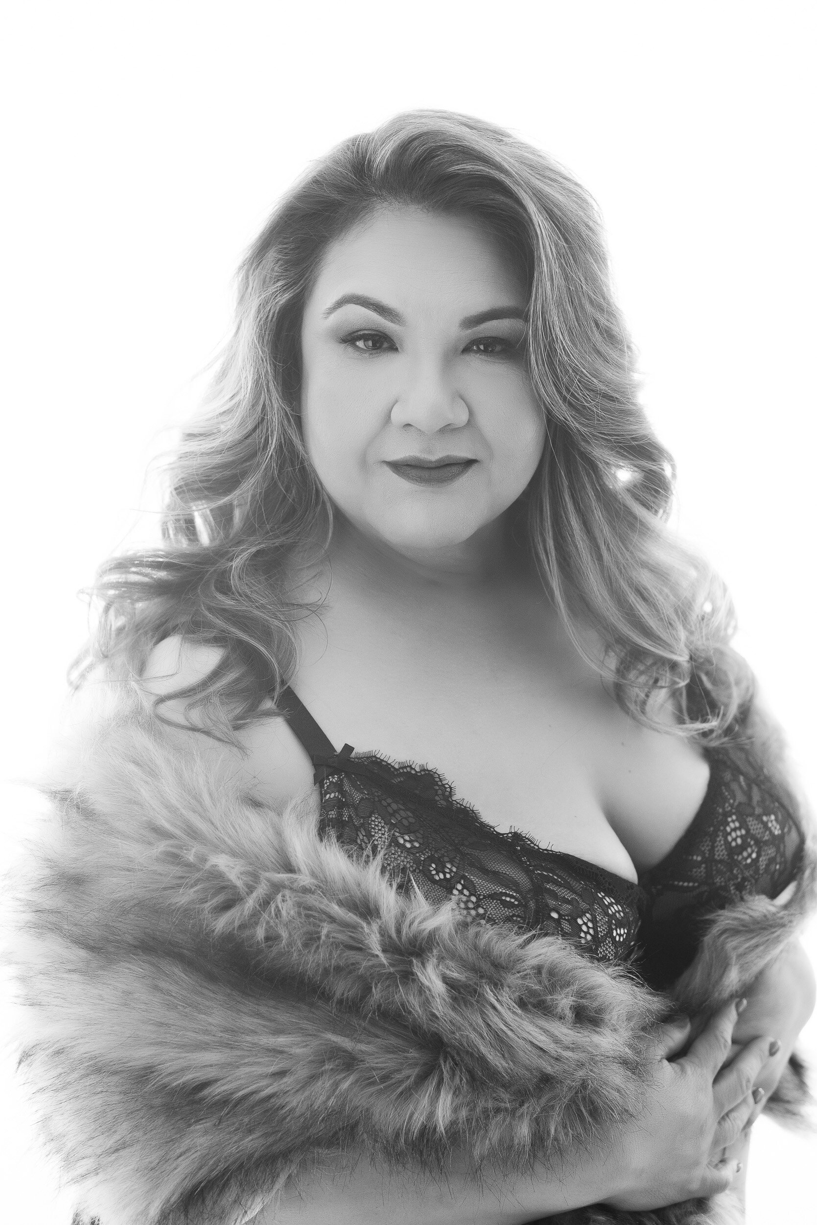 sultry modern boudoir portrait in black and white with gorgeous fur wrap of plus size client and lingerie shot at Ana Lanier Portrait Studio in Dallas TX