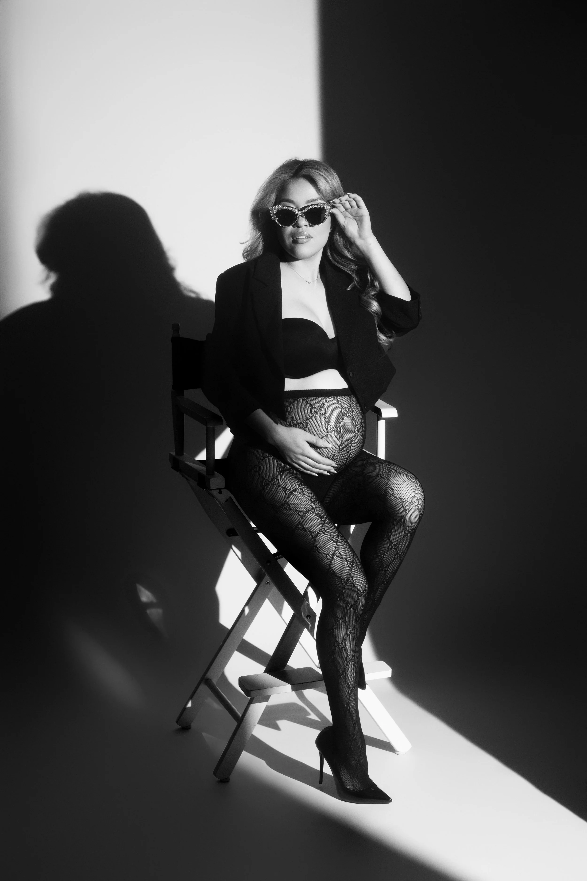 Black-and-white fashion-inspired maternity portrait with dramatic studio lighting and bold styling, photographed in Dallas.