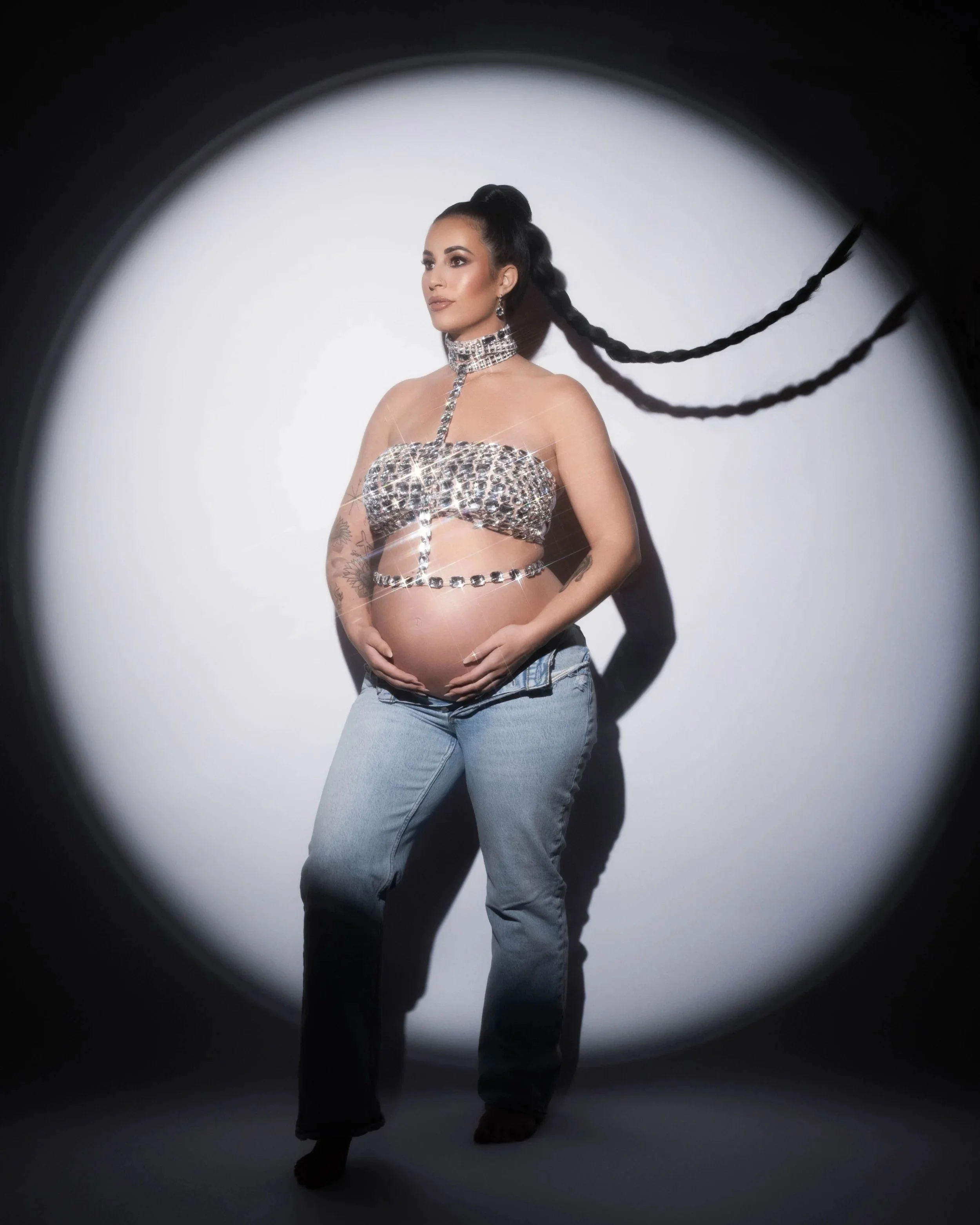 Editorial maternity portrait with dramatic spotlight at a Carrollton, TX photography studio