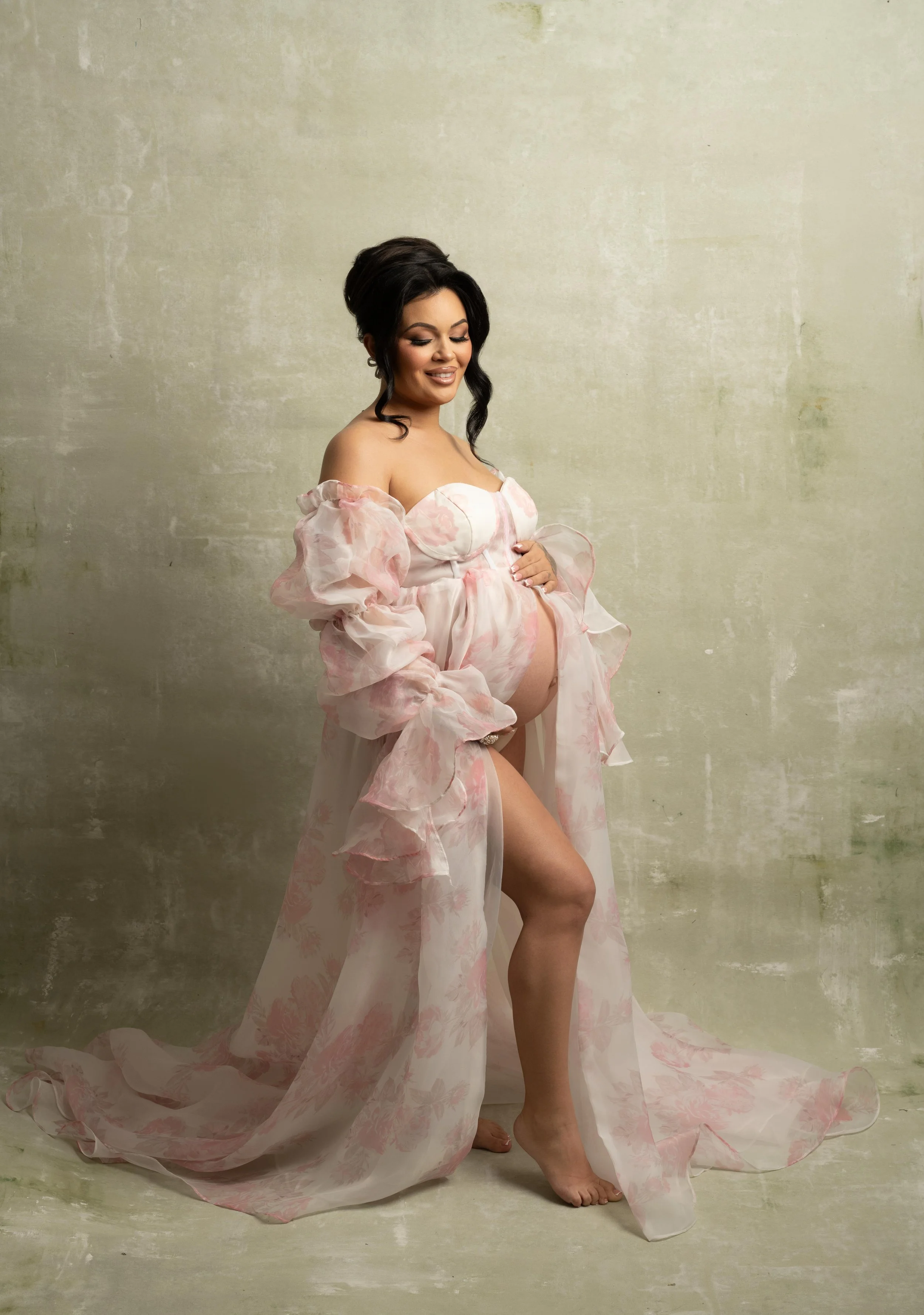 Pregnant woman in a soft pink gown photographed in a Dallas maternity photography studio.