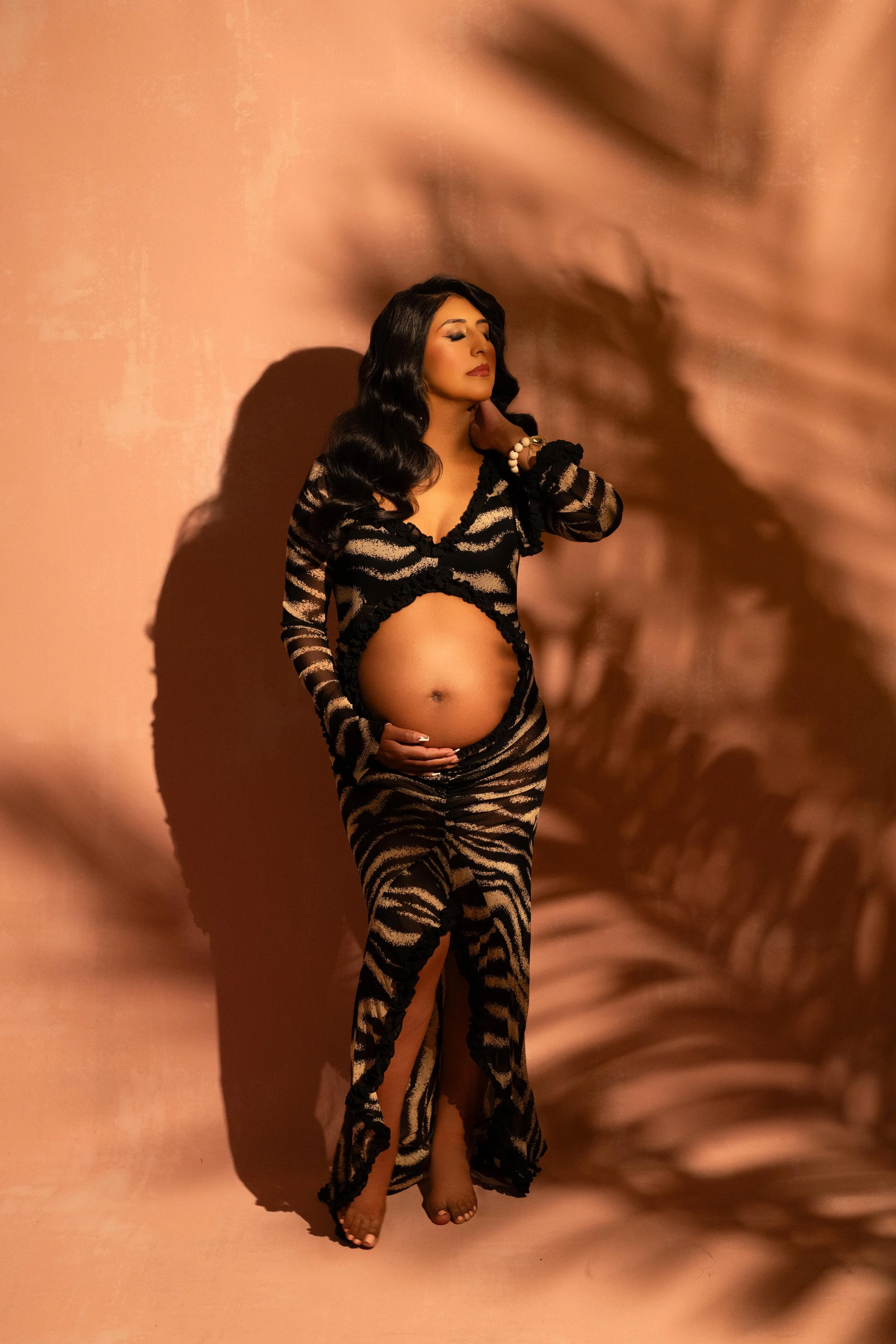 Fashion-inspired maternity portrait with dramatic shadow lighting and bold styling, photographed in Carrollton, Texas.