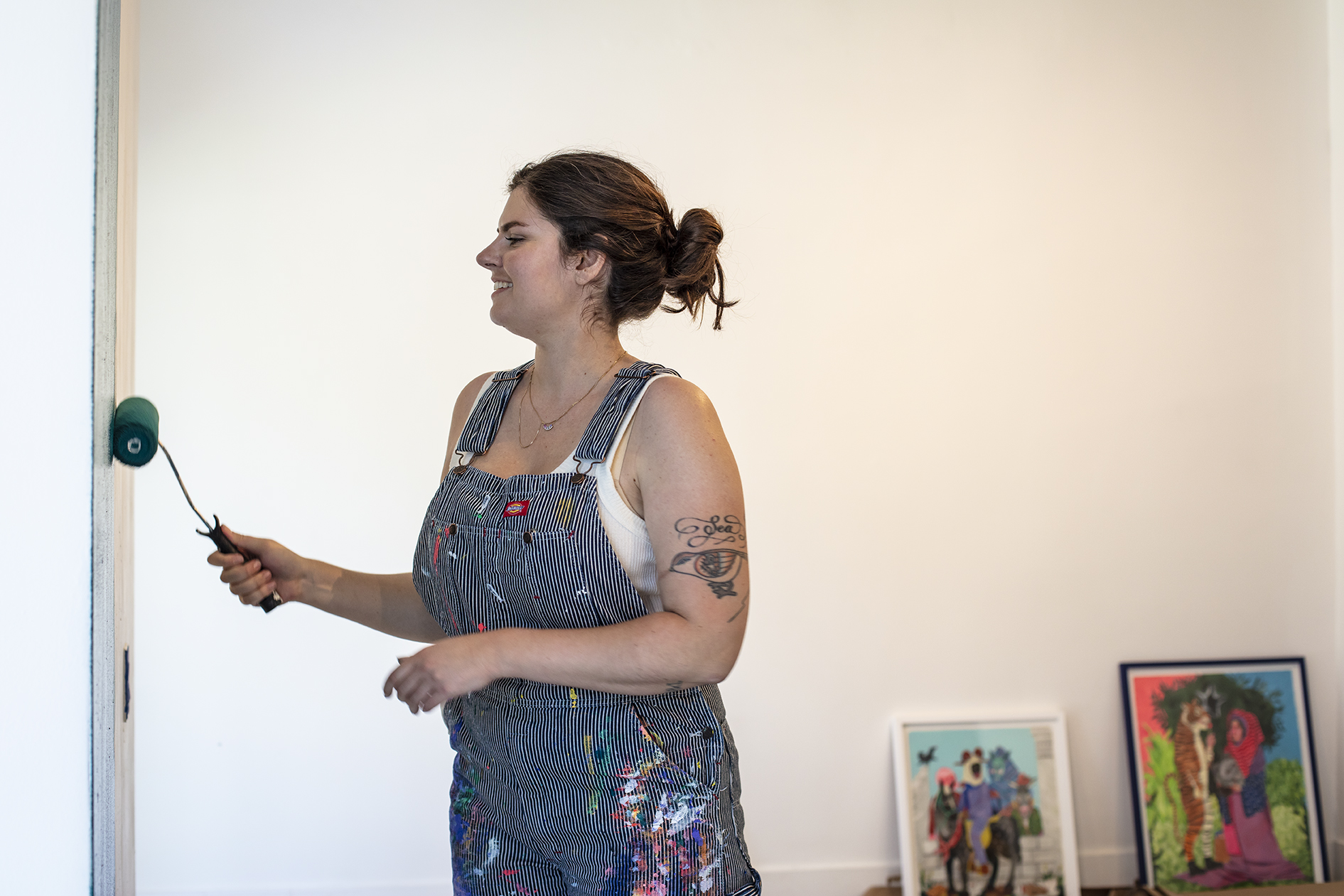 Artist, Stacey Rozich, installing her latest body of work, “Some Sort of Disrepair.” Behind the scenes photo by L. Herrada-Rios