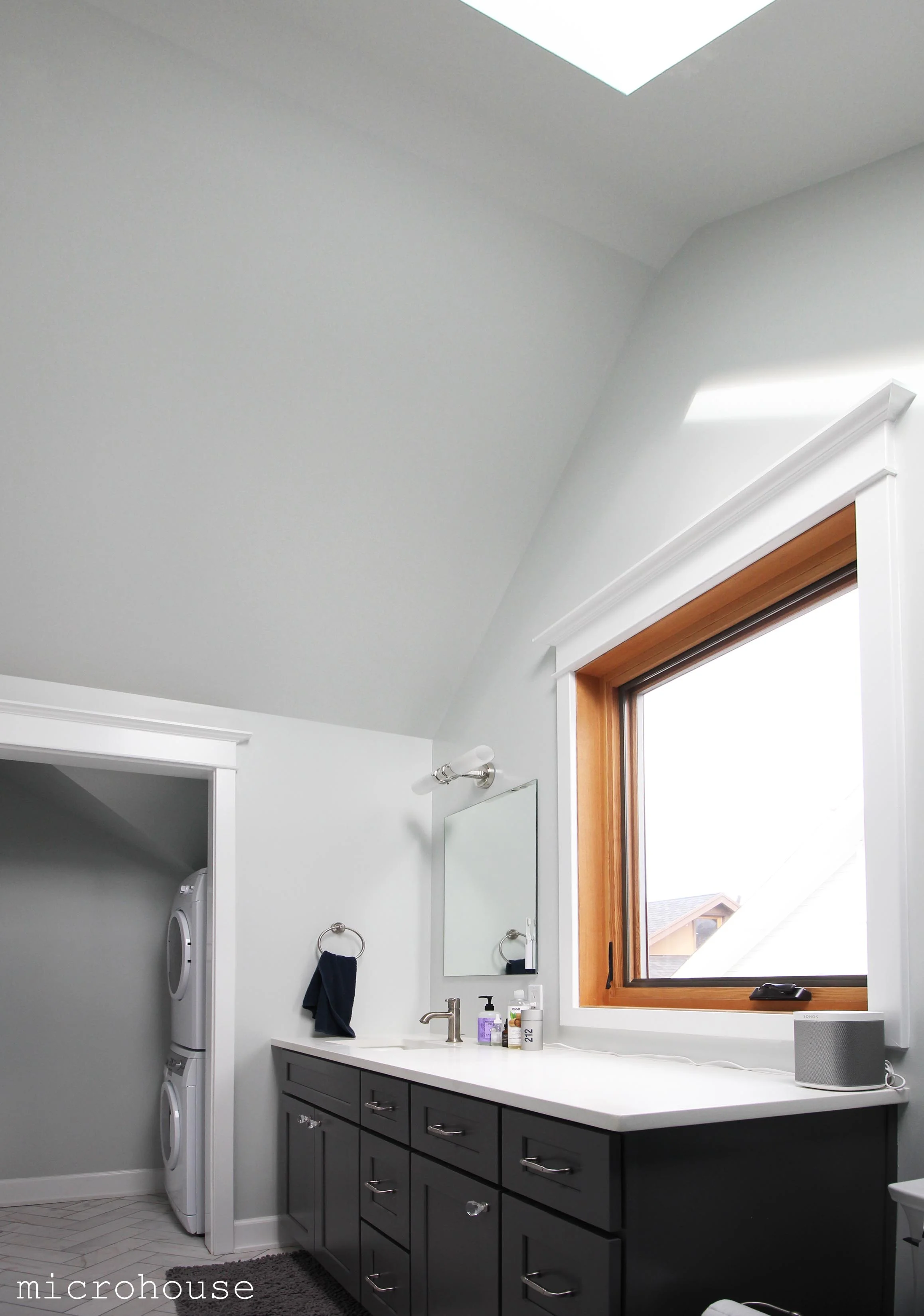 The master bath features vaulted ceilings and skylight. A laundry room is tucked off to one side under the eaves.