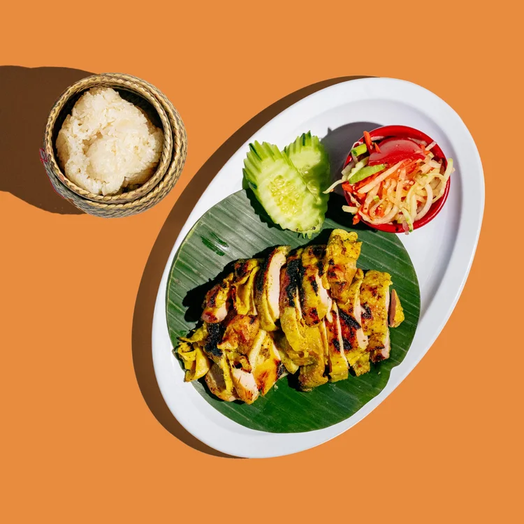 Grilled gai yang chicken on a banana leaf with sticky rice
