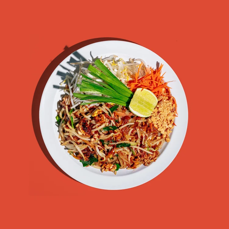 Pad thai with bean sprouts, peanuts and a lime wedge