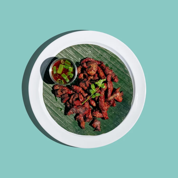 Thai pork jerky with a spicy dipping sauce and cilantro