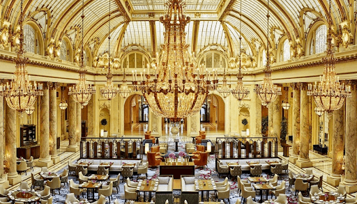 Photo of gorgeous lobby of fancy hotel with chandeliers and a glass ceiling