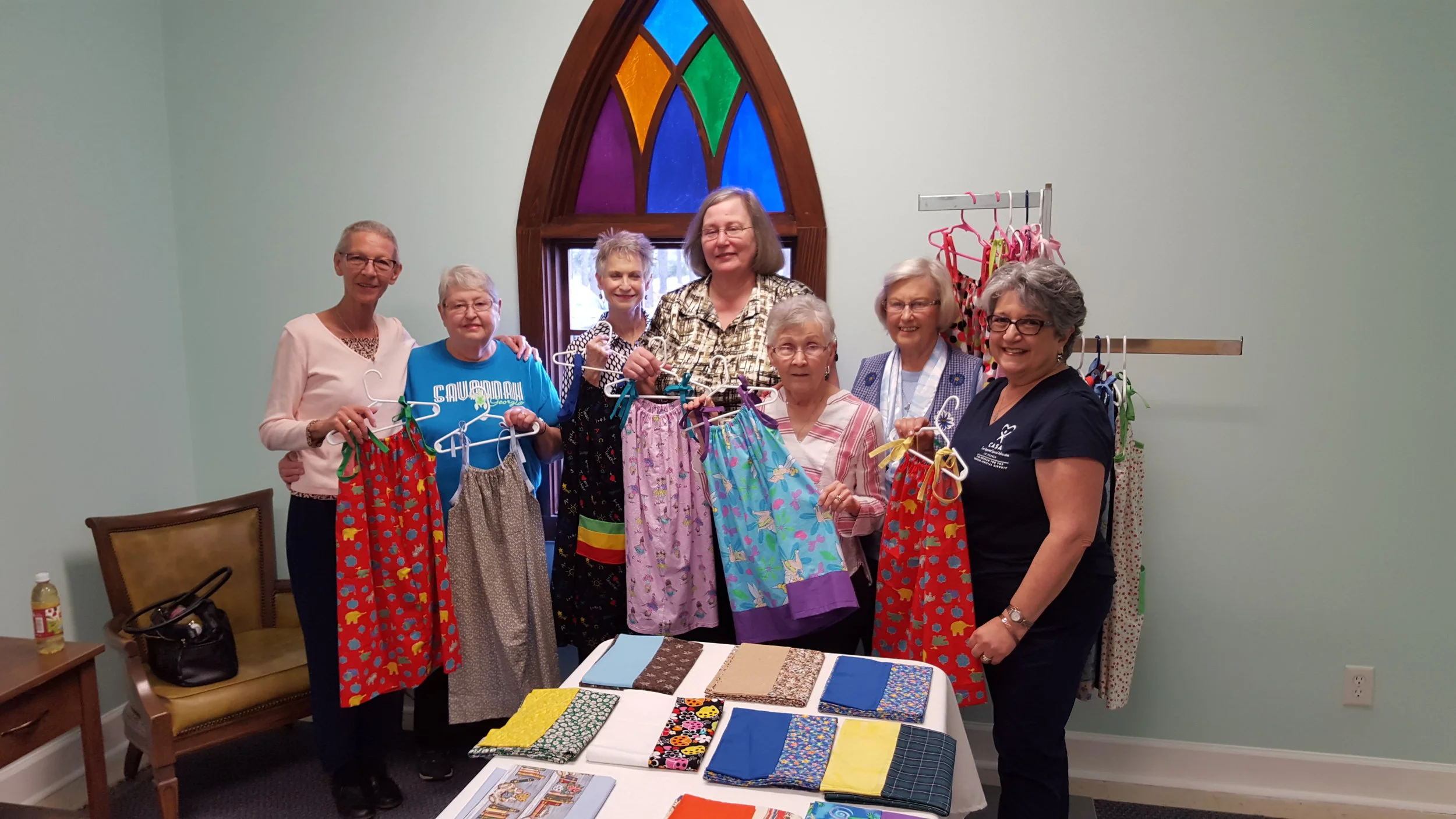 Ladies from the church showing dresses they sowed to support CASA.