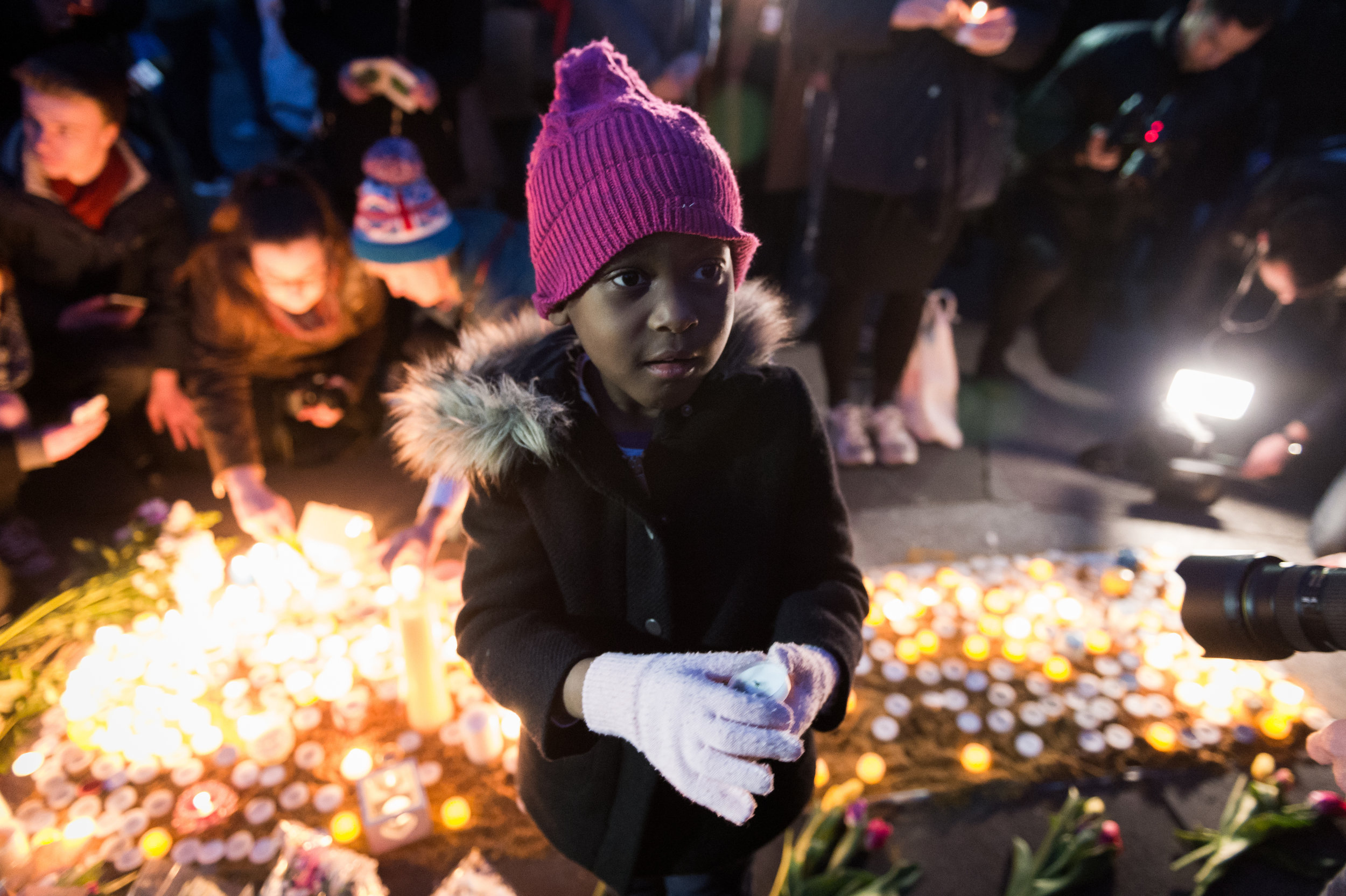  A young girl beckons her father to help light a candle in memory of those who lost their lives in the terror attack.&nbsp; 