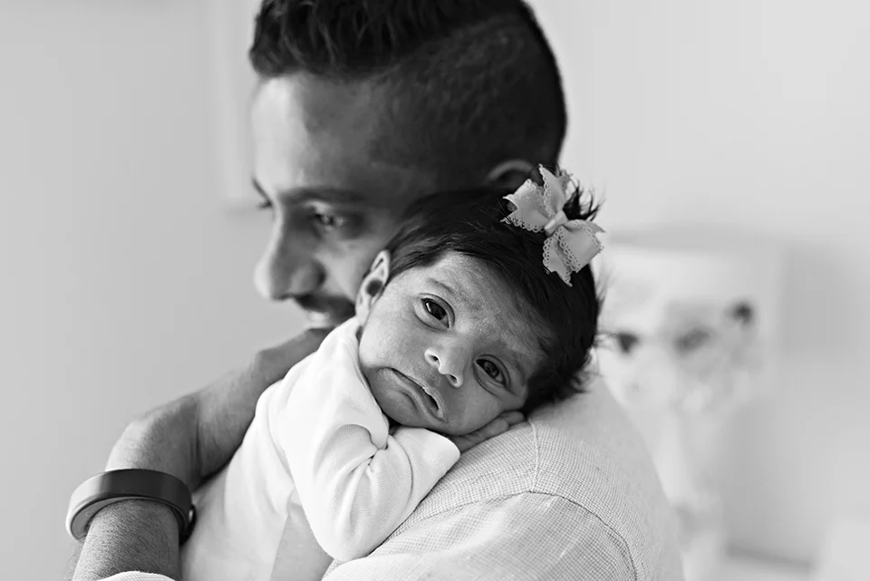 dad holding newborn with lots of hair and a bow southington connecticut newborn photographer