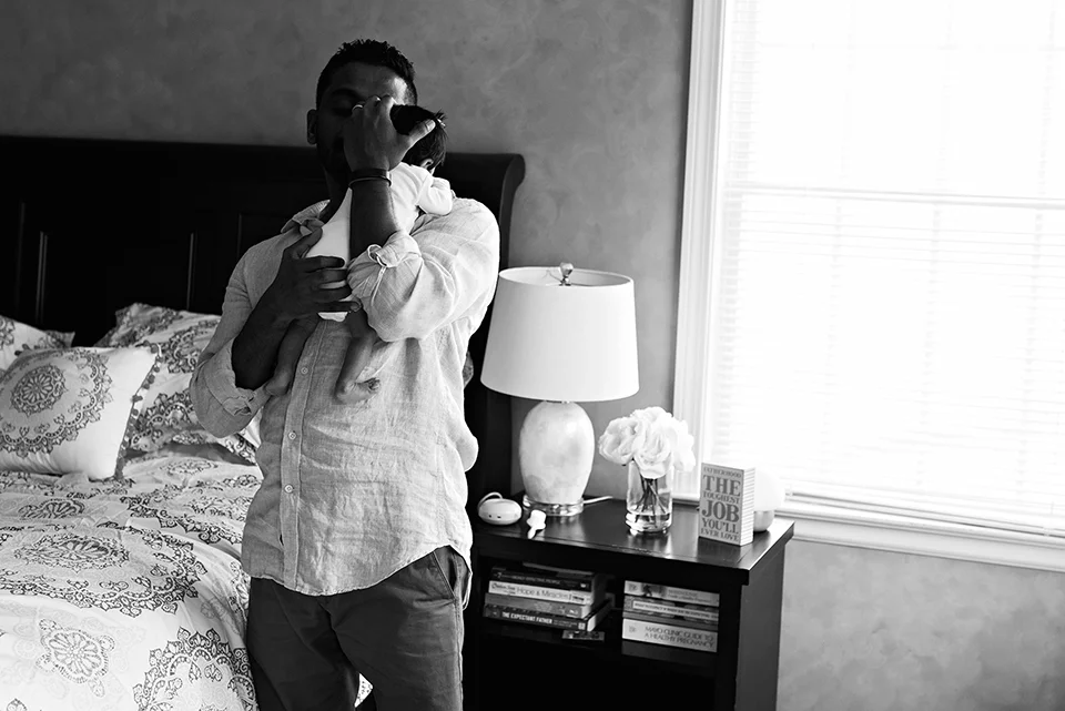 dad holding newborn daughter in bedroom southington connecticut newborn photographer