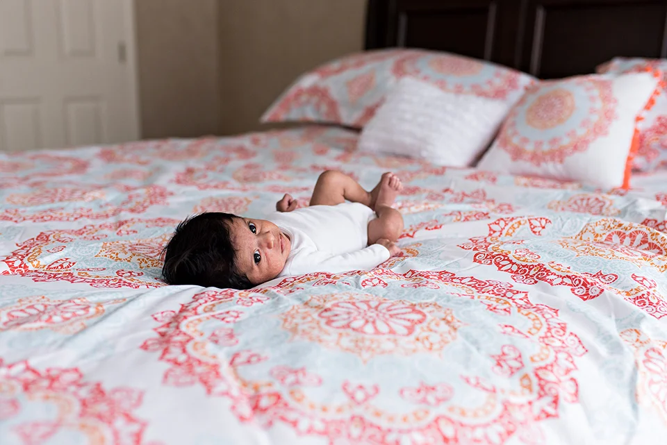 newborn laying on mom and dads bed southington connecticut newborn photographer