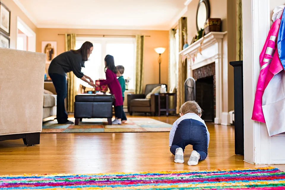 baby crawling into living room while mom plays with kids west hartford ct documentary family photography