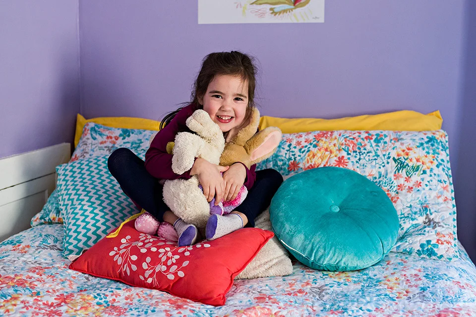 girl sitting on bed hugging stuffed animals west hartford connecticut family documentary photography