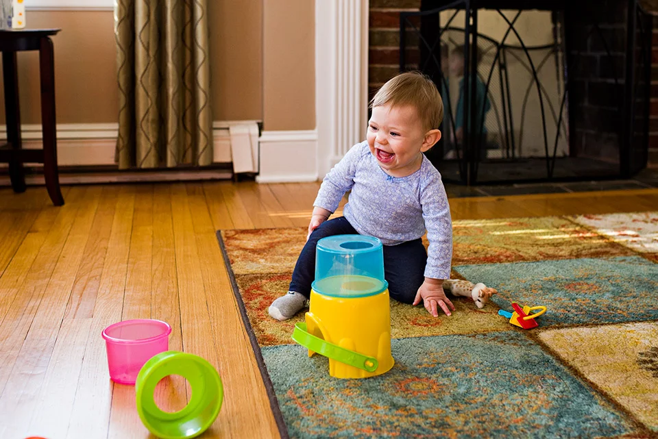 baby girl laughing after knocking down stacking cup toy west hartford ct family documentary photography