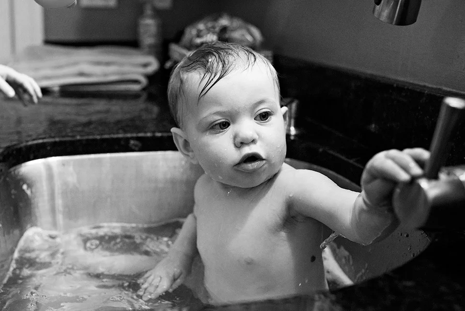 baby taking bath in kitchen sink west hartford connecitcut family documentary photography